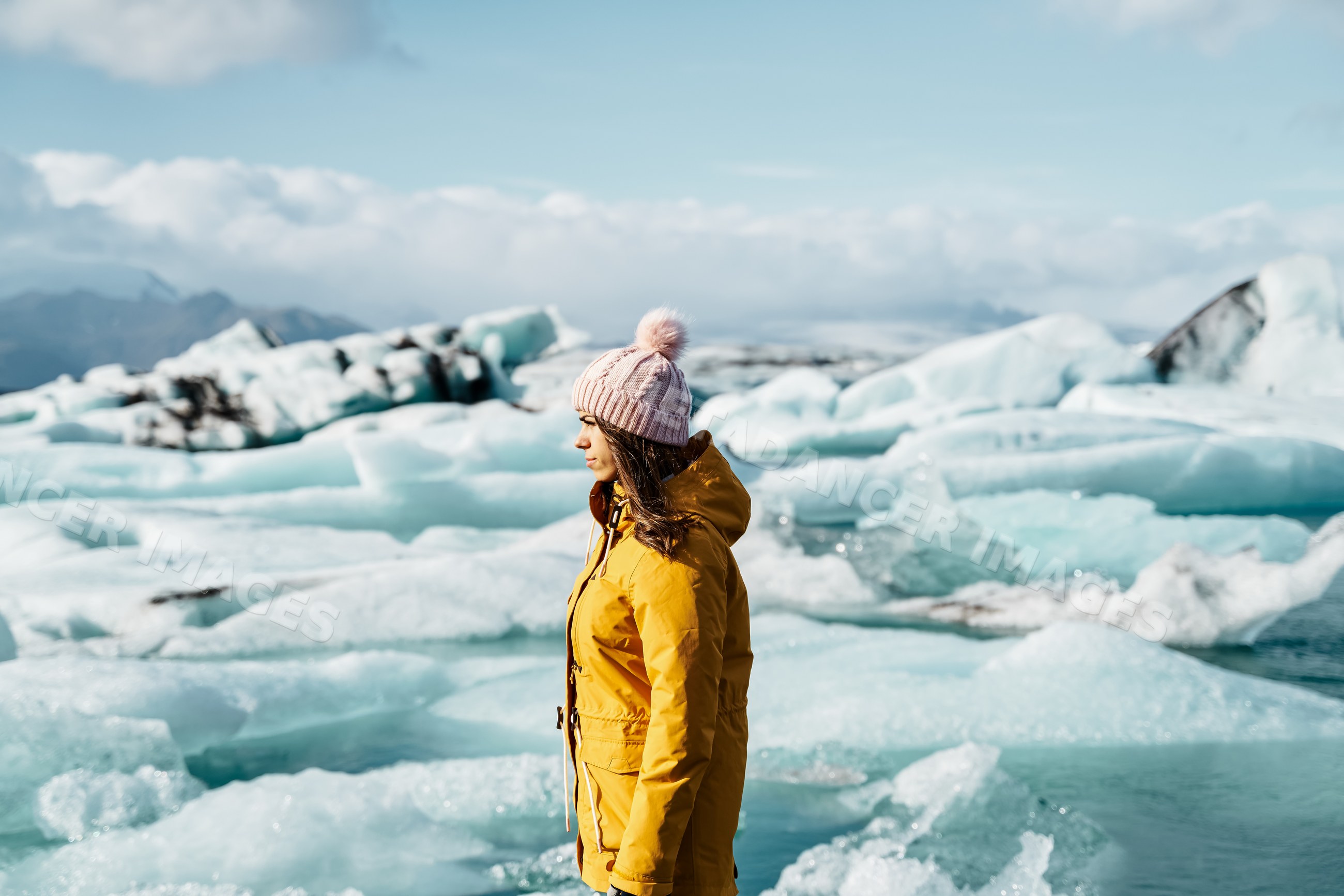 A white woman stands among glacier ice blocks
