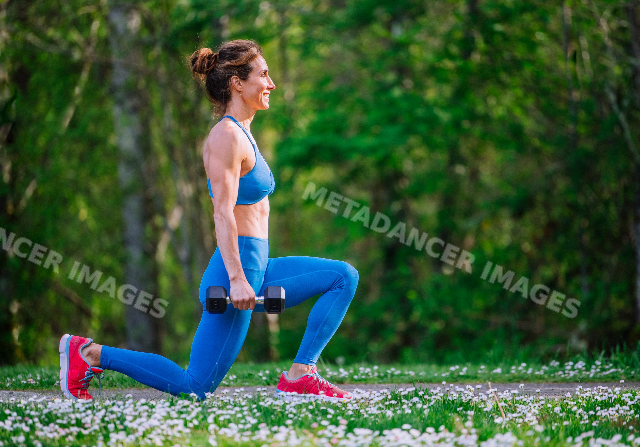 White woman performing strength training lunges outdoors