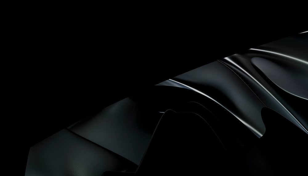 Close-up of smooth black leather with glossy folds and shadows