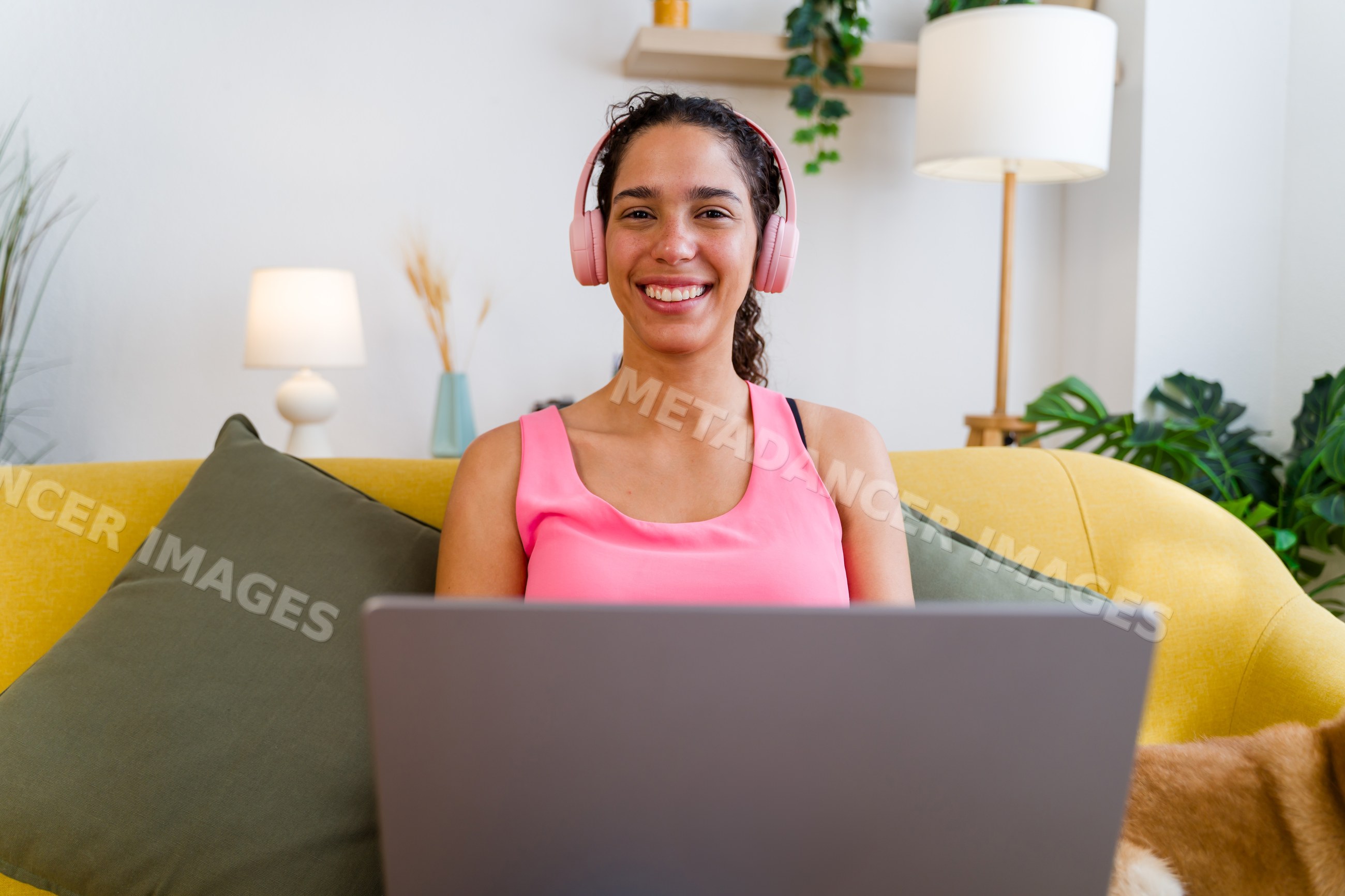 A Hispanic woman with headphones smiling