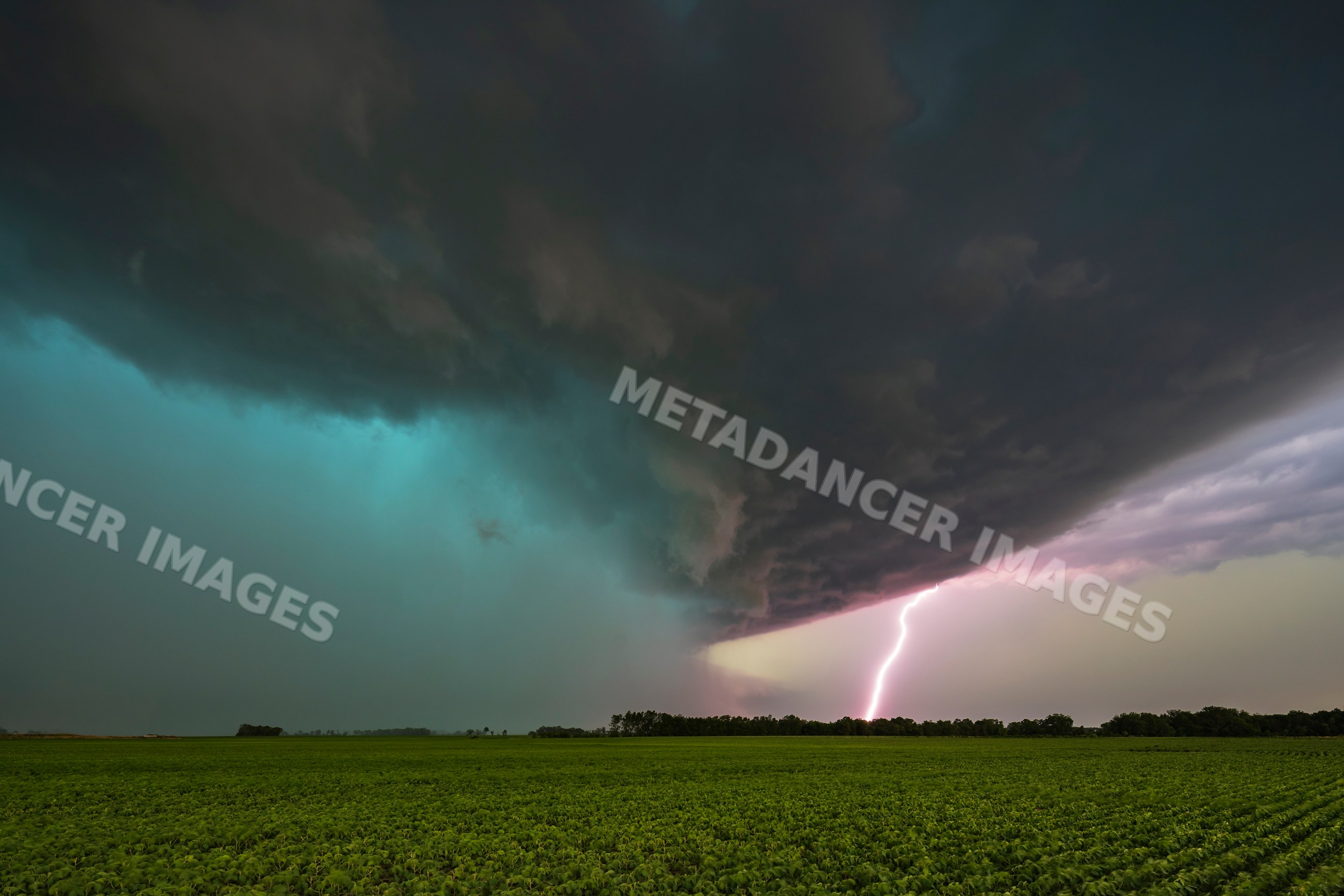 Tornado-warned Supercell storm with Lightning Strike over field