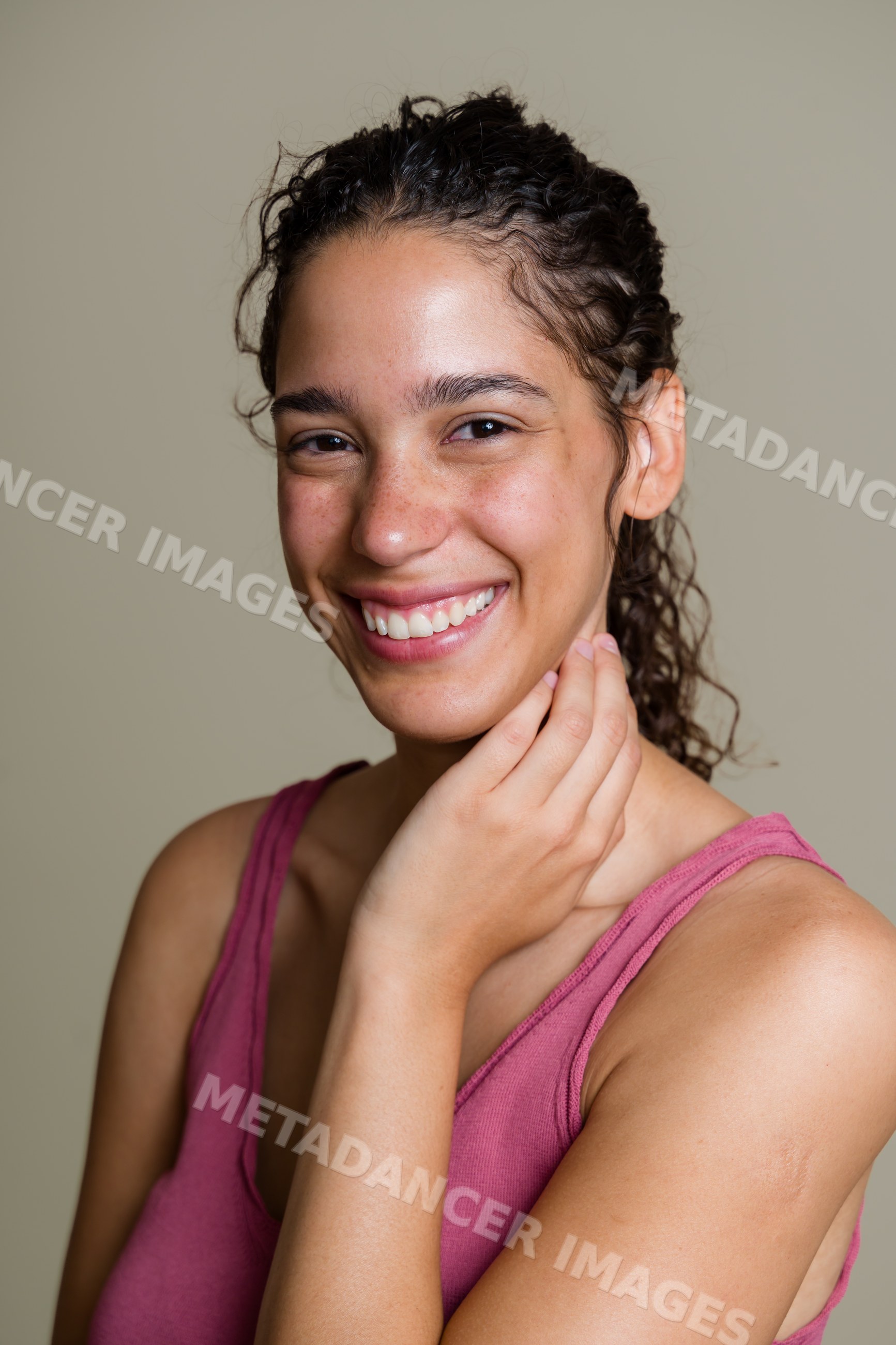 Portrait of smiling Hispanic woman touching her face