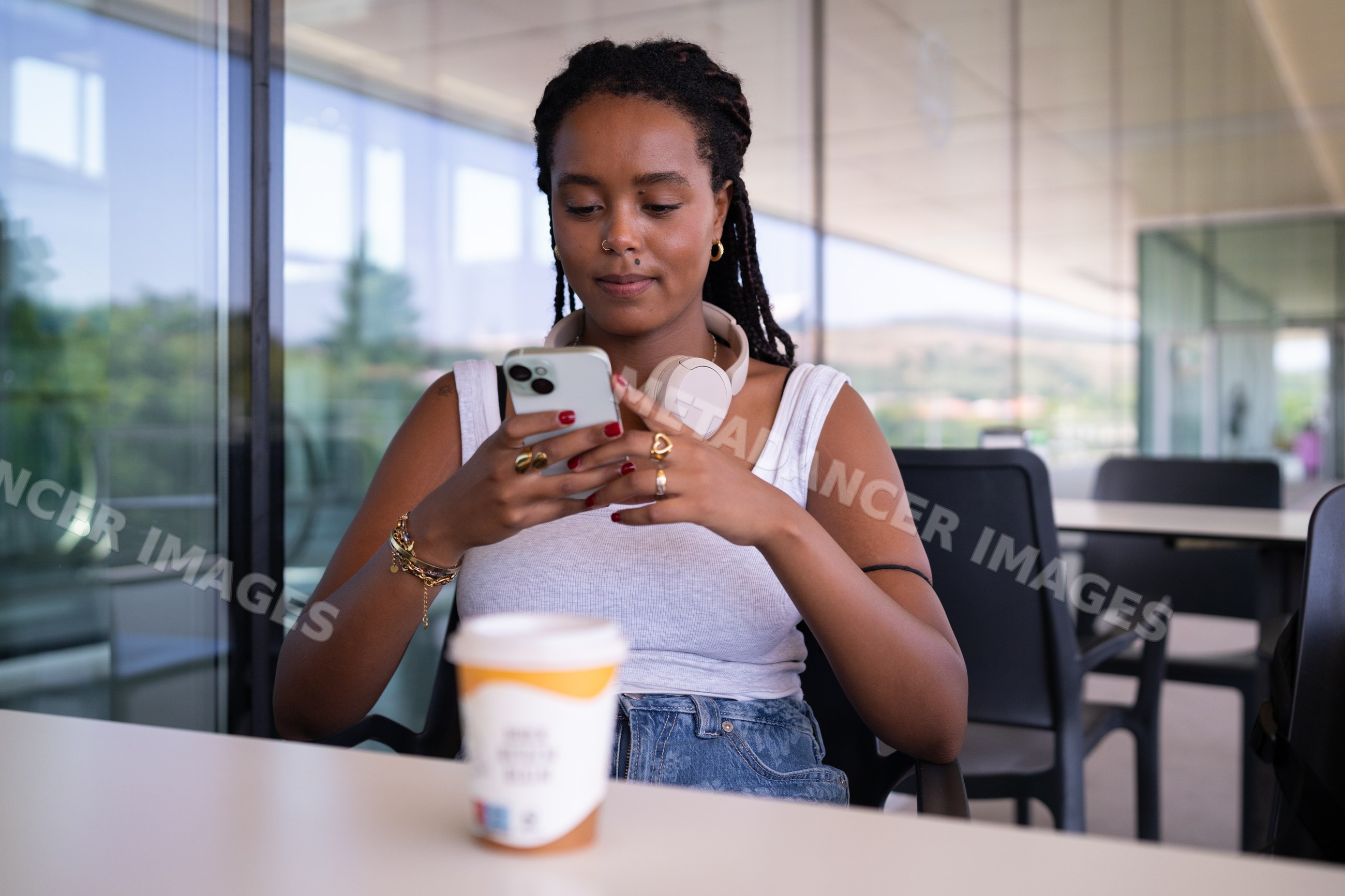 A African American woman uses her smartphone seated