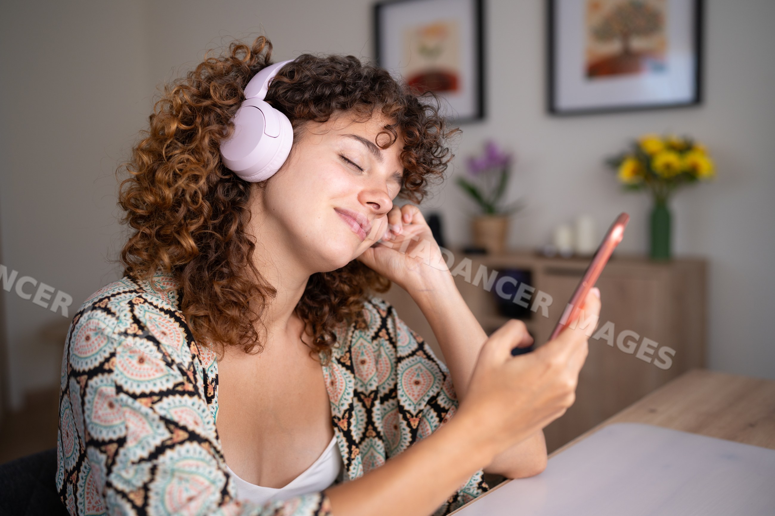 White woman listening to music with headphones at home in Spain