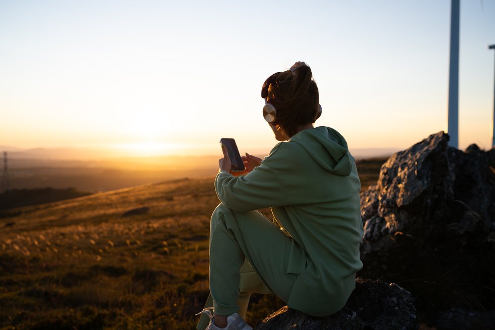 White Woman with headphones using smartphone outdoors