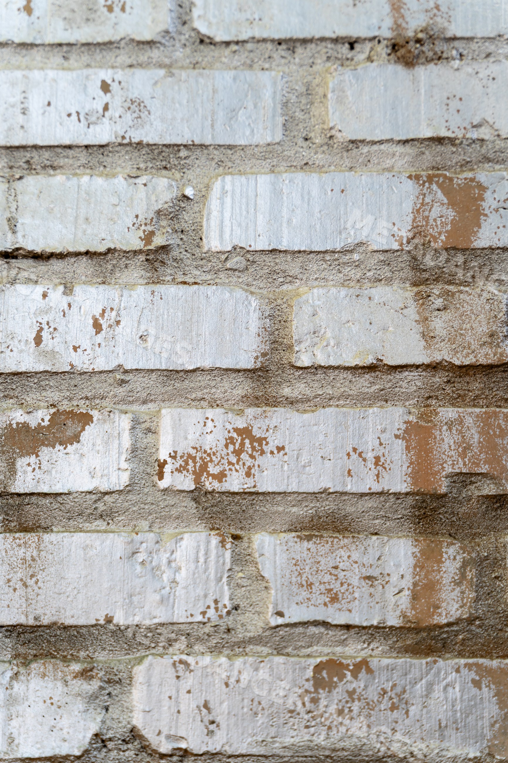 White painted brick wall with weathered cement mortar texture