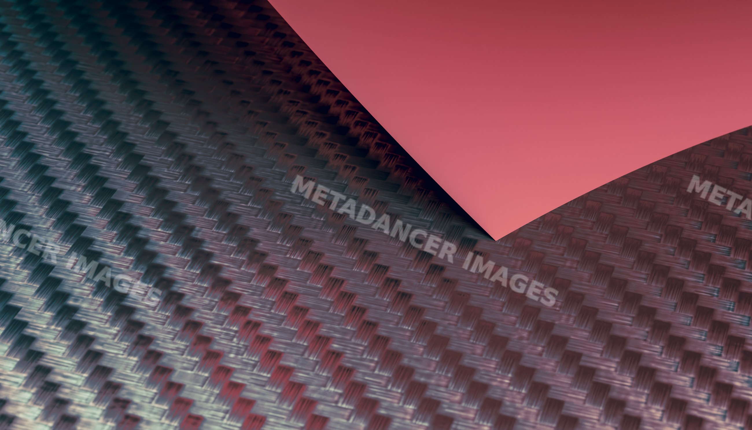 Close-up view of carbon fiber fabric with red paper overlay