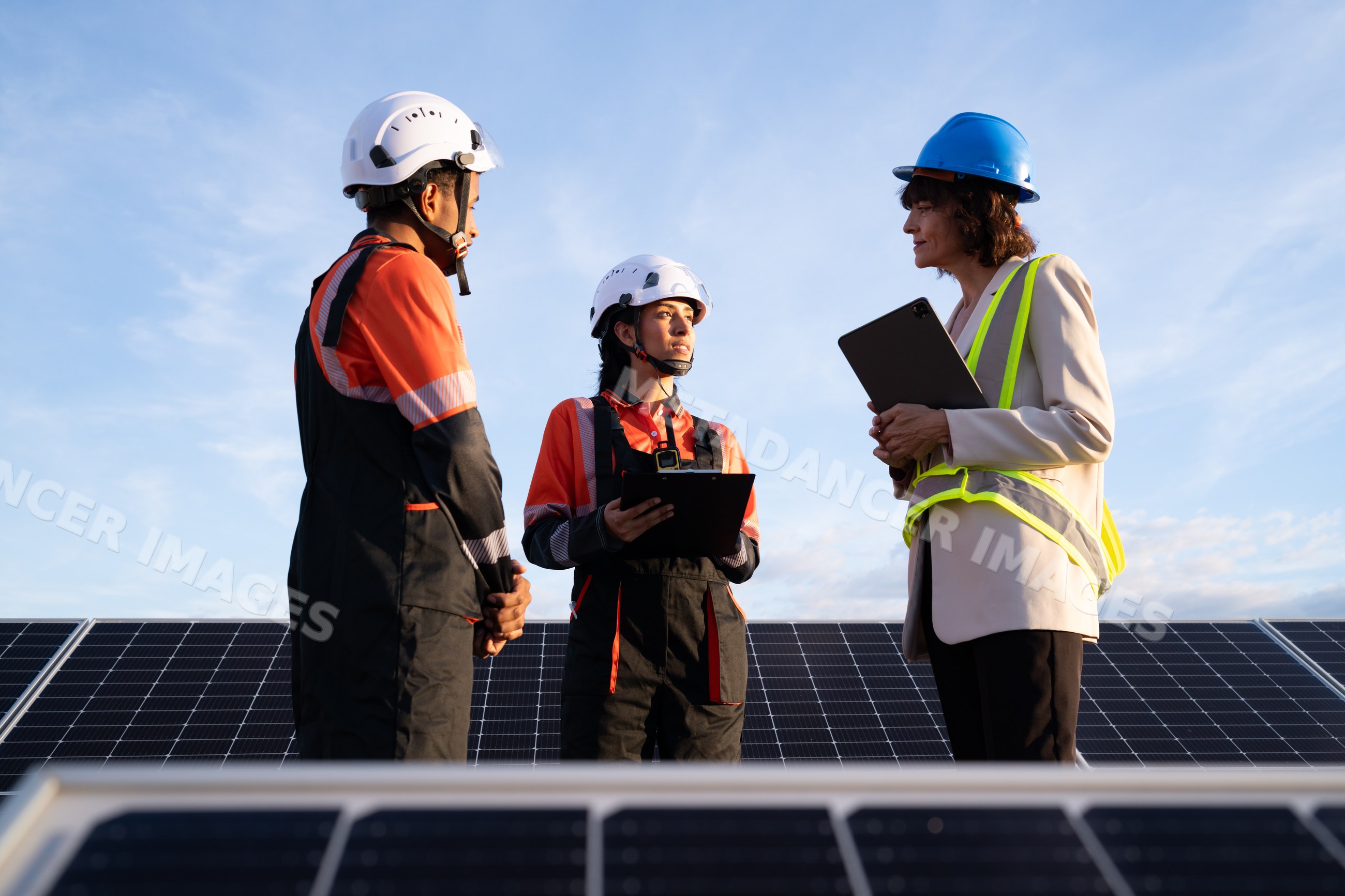 Engineers discussing solar panels outdoors