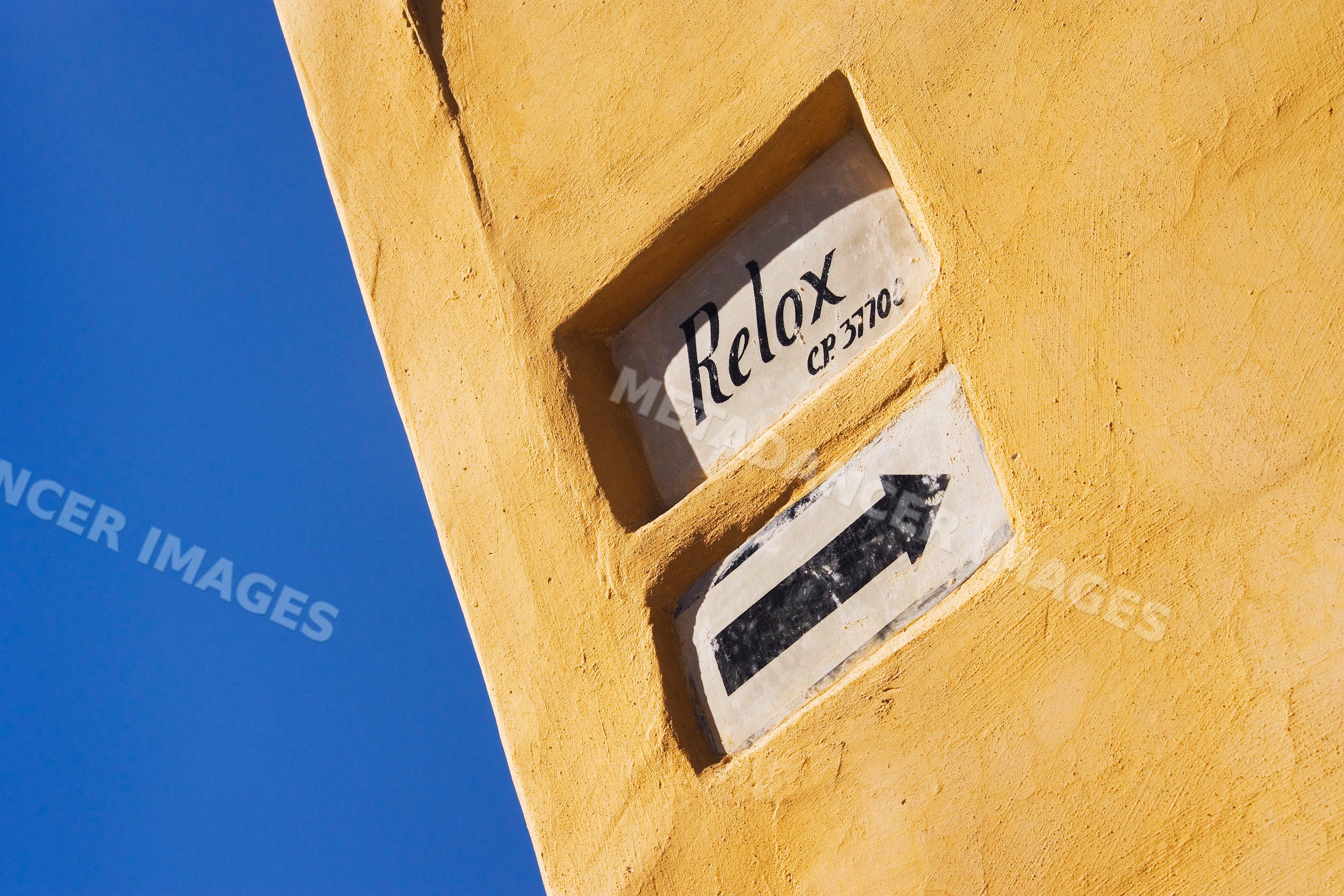 Street sign with relax and arrow on yellow wall