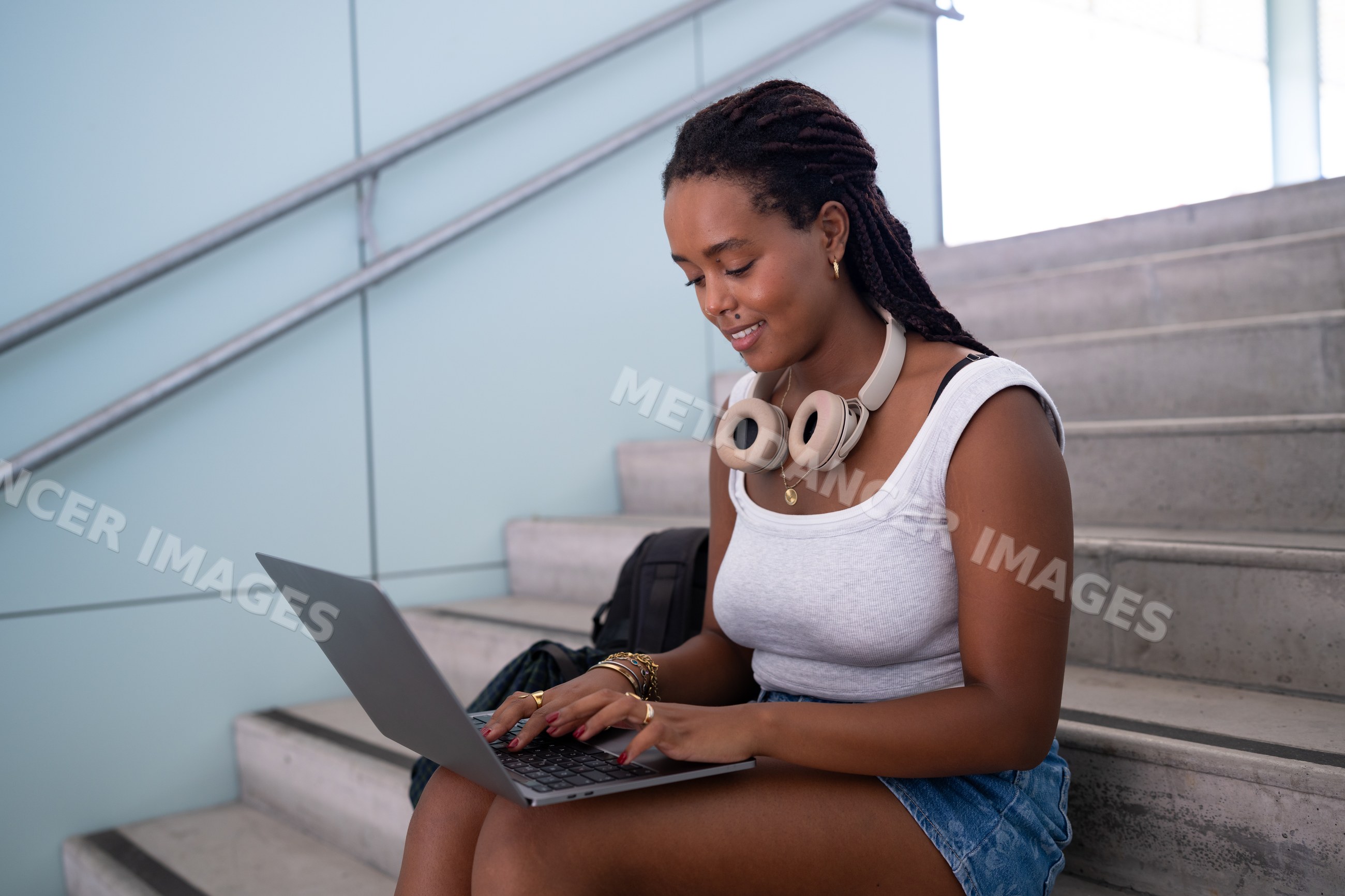 A young African American woman types on a laptop
