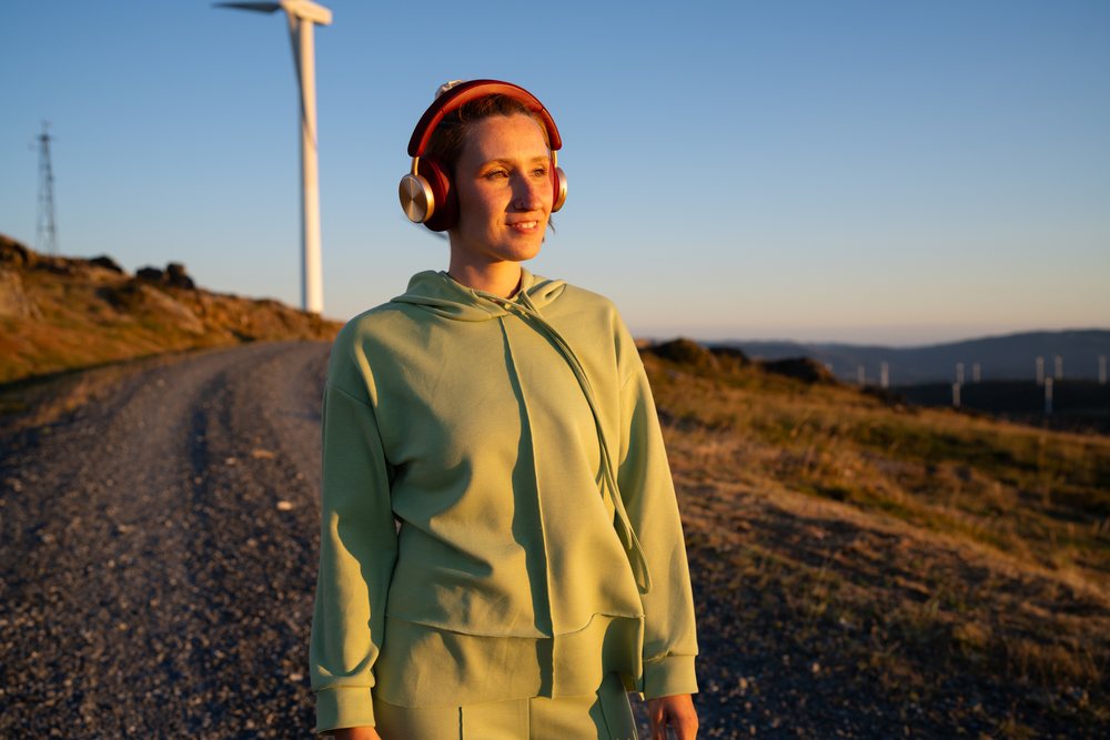 White Woman wearing headphones walking