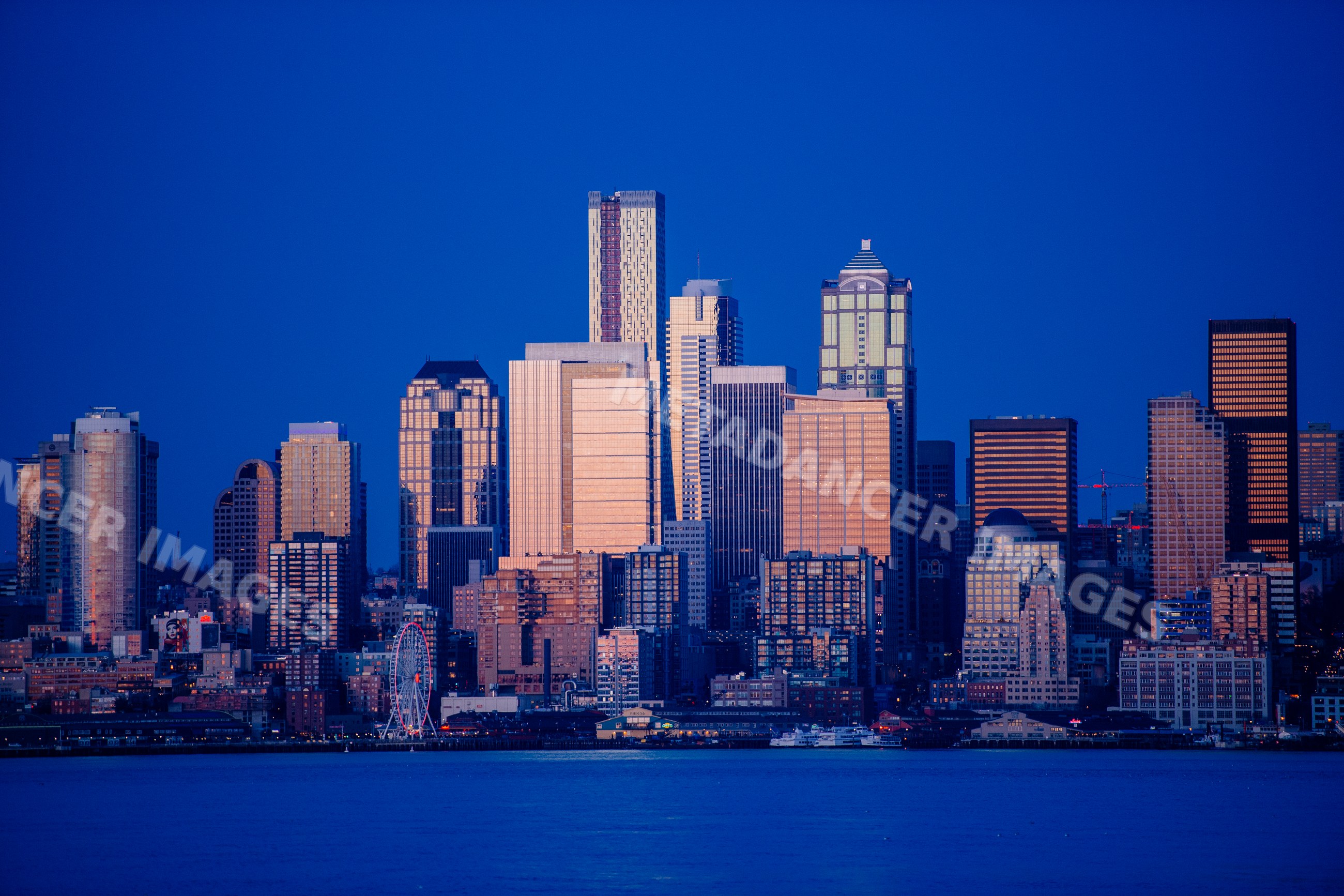 Seattle city skyline with waterfront and ferris wheel at dusk