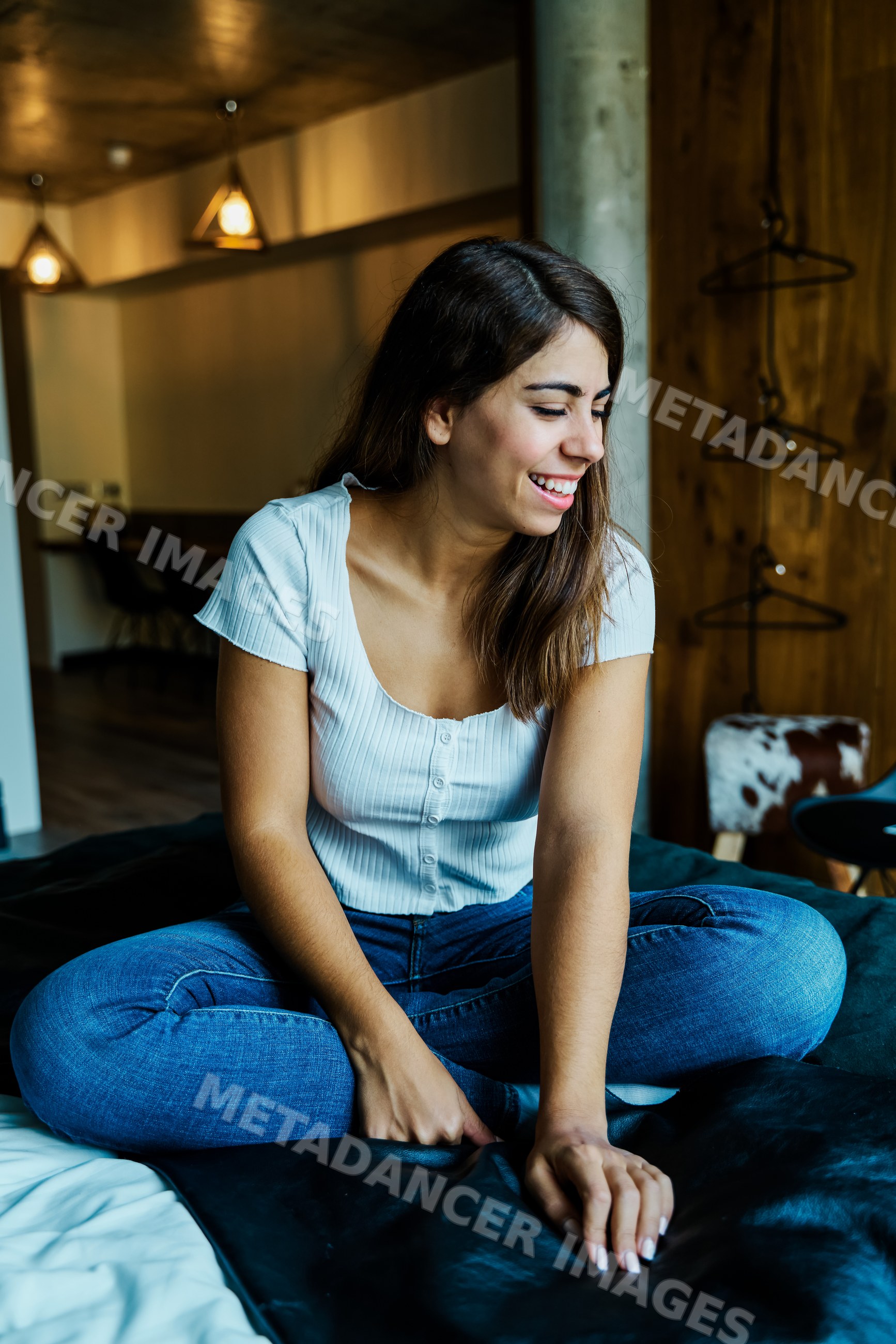 A young woman relaxes smiling in a cozy modern room in a hotel