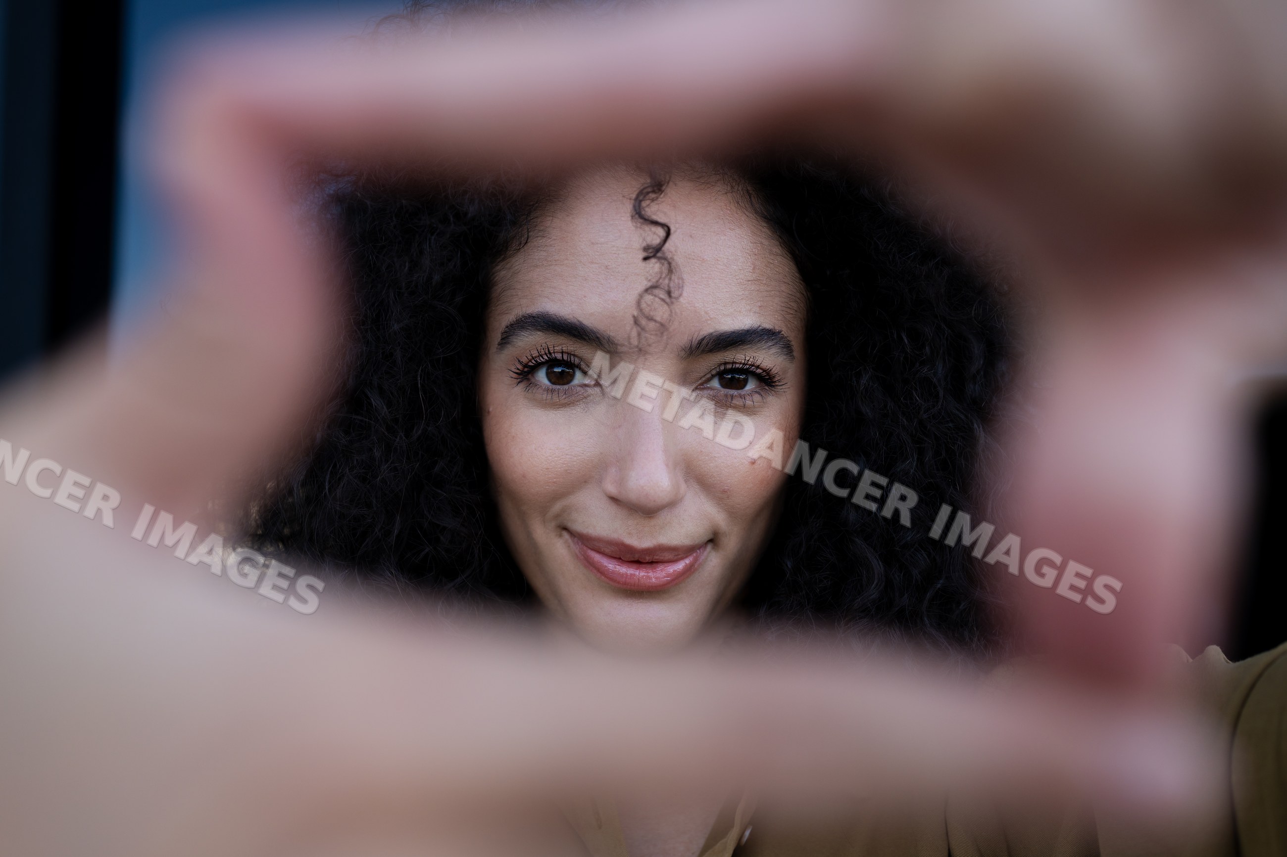 Close-up portrait of a smiling woman with curly hair framing her face