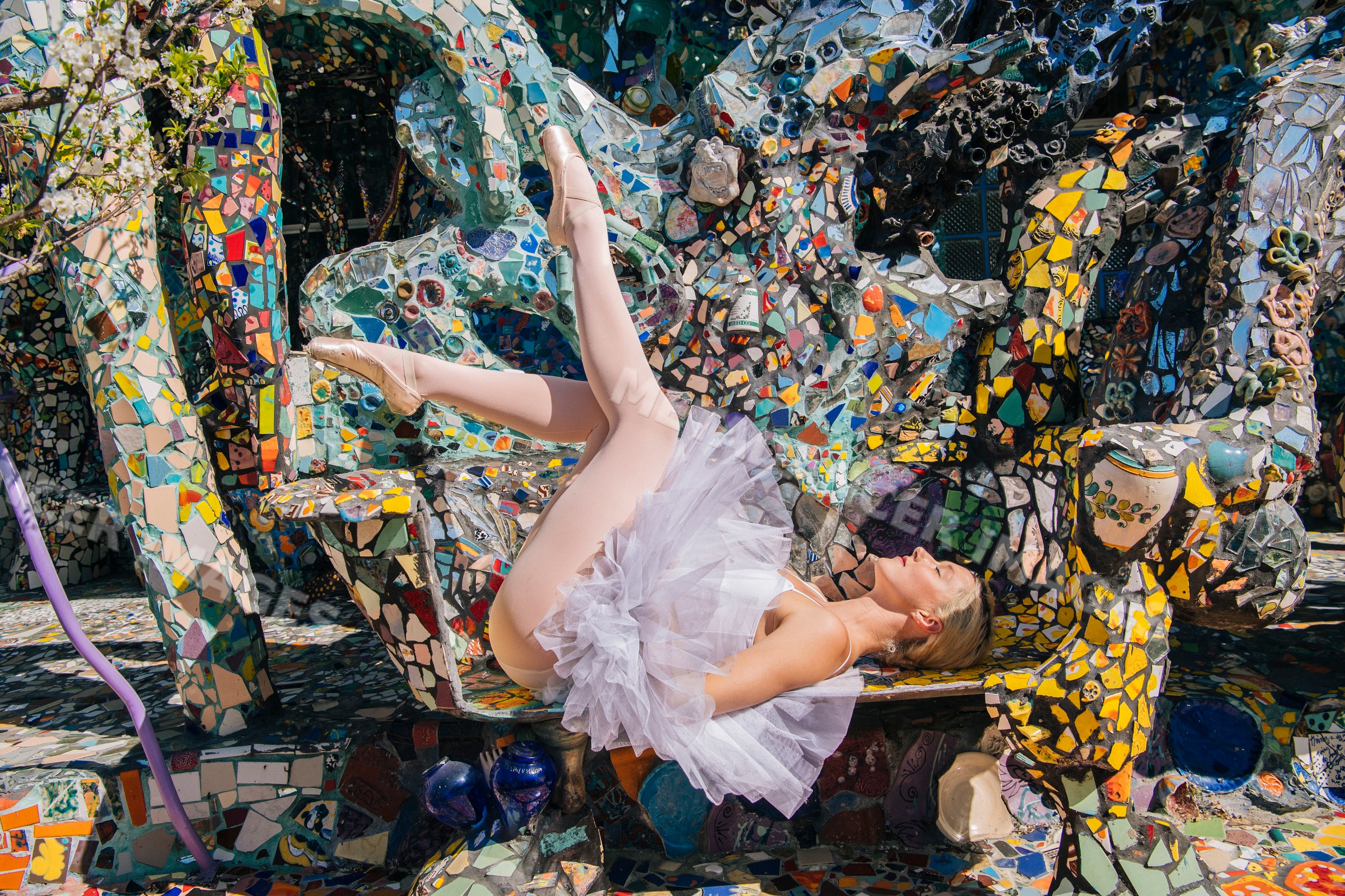 Ballerina reclining in tutu on colorful mosaic sculpture bench