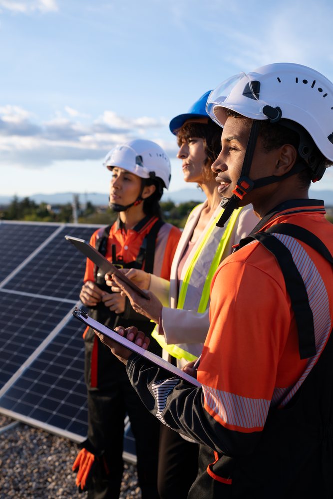 Engineers inspecting solar panels for renewable energy outdoors