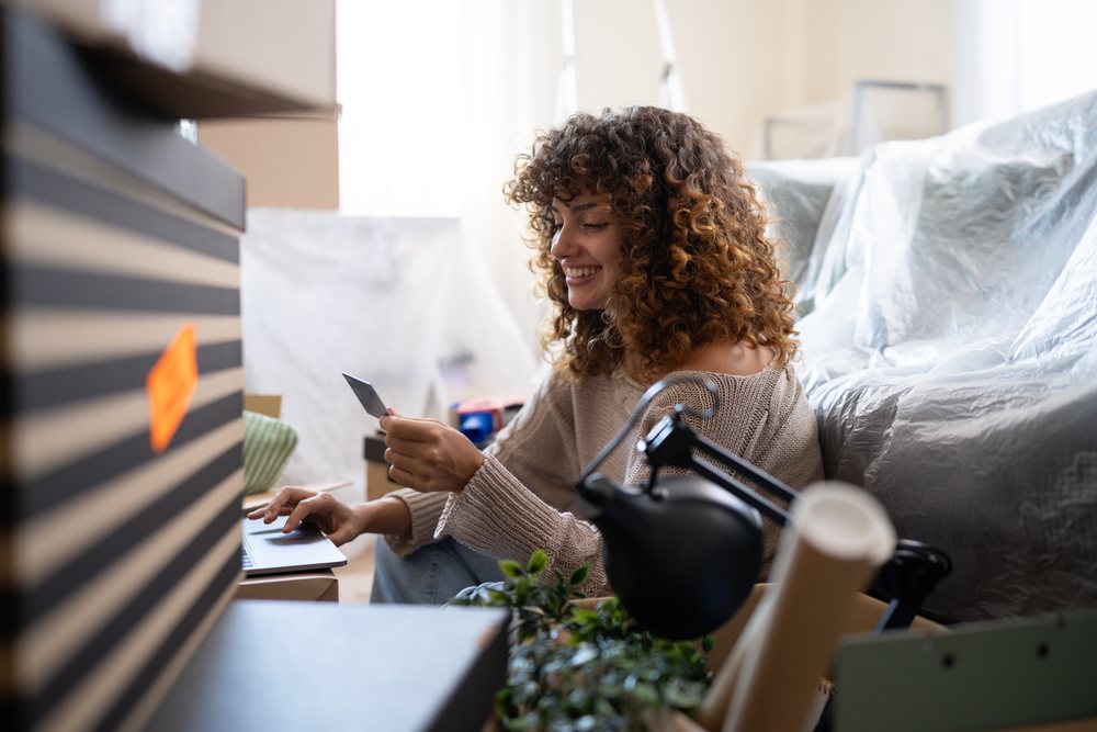 White woman using credit card on laptop