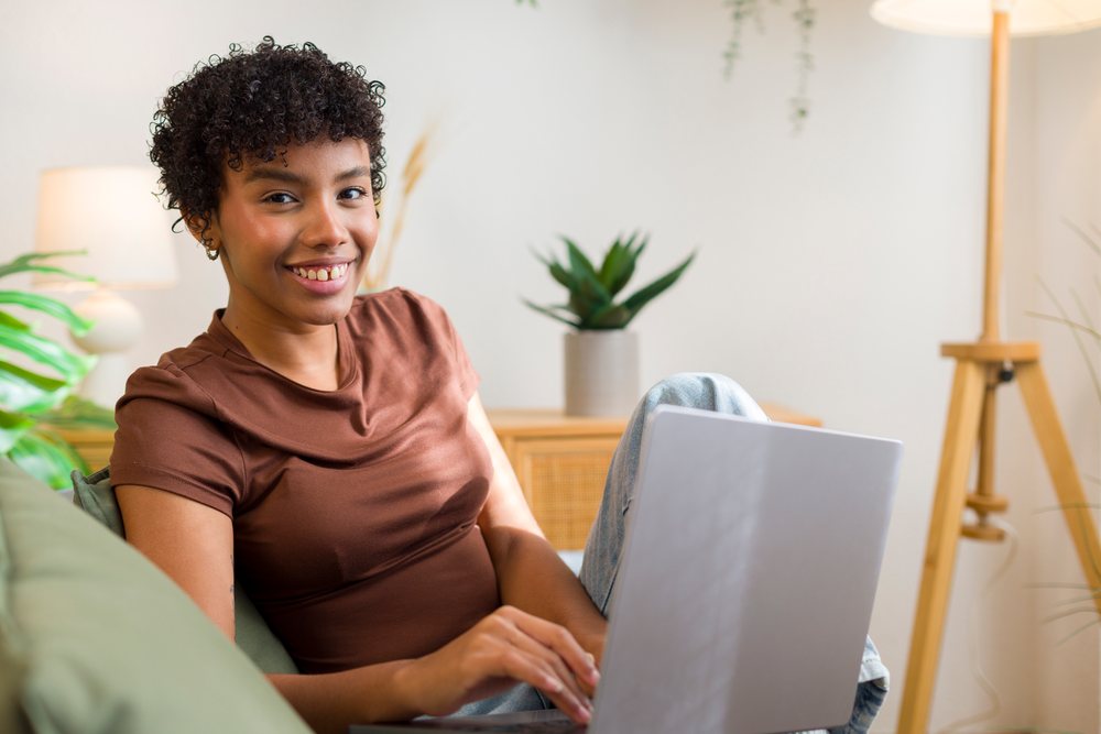 Young African American woman using laptop in cozy home setting