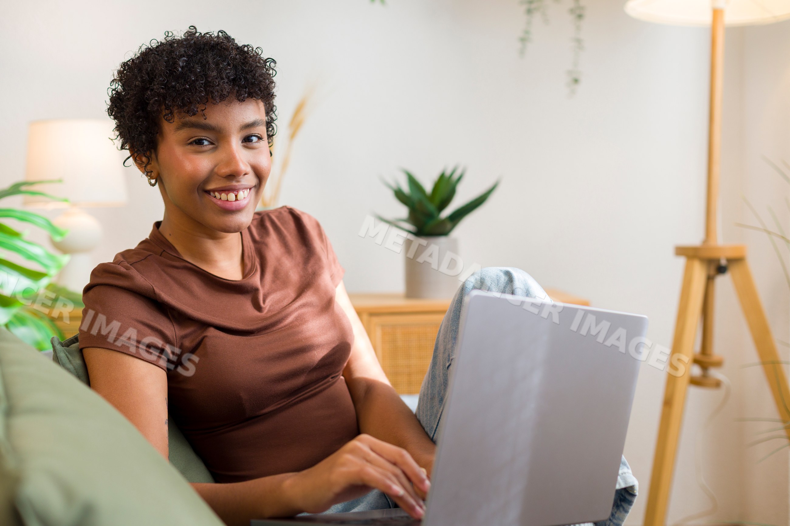 Young African American woman using laptop in cozy home setting