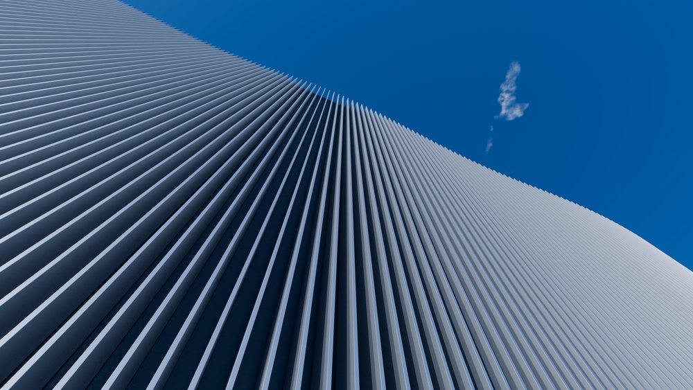 Modern building facade with vertical concrete lines and blue sky