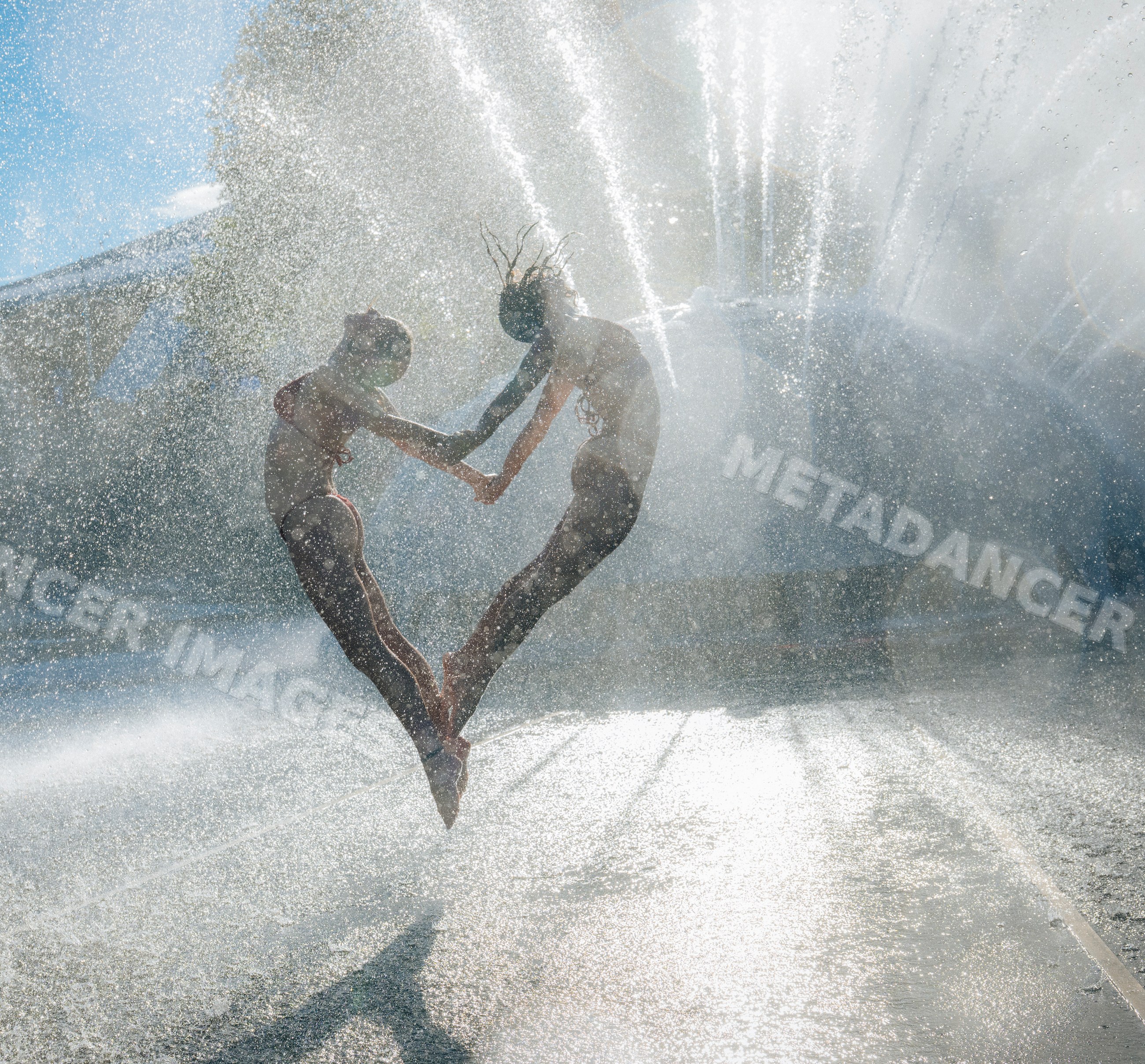 Two white women jumping and holding hands