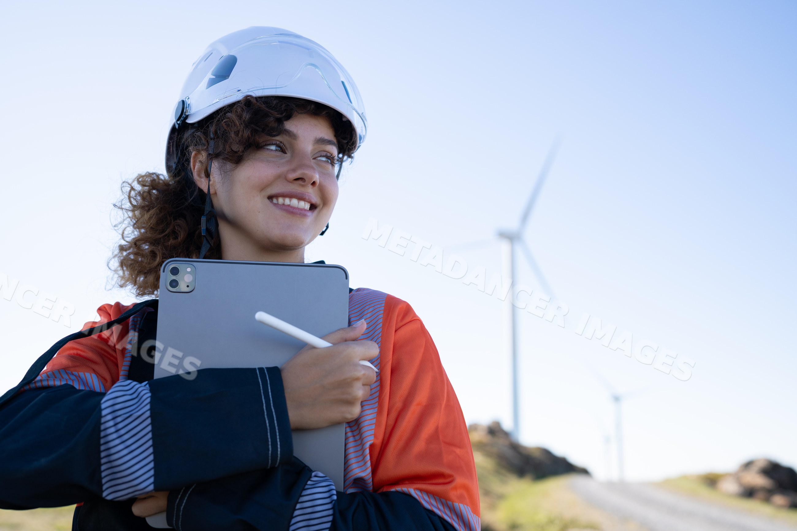 White woman engineer using tablet at wind farm in Galicia, Spain