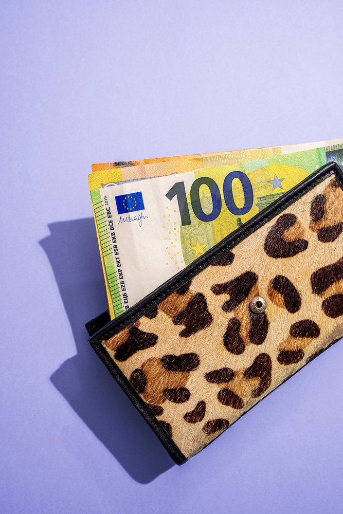 Wallet with euro notes on purple background