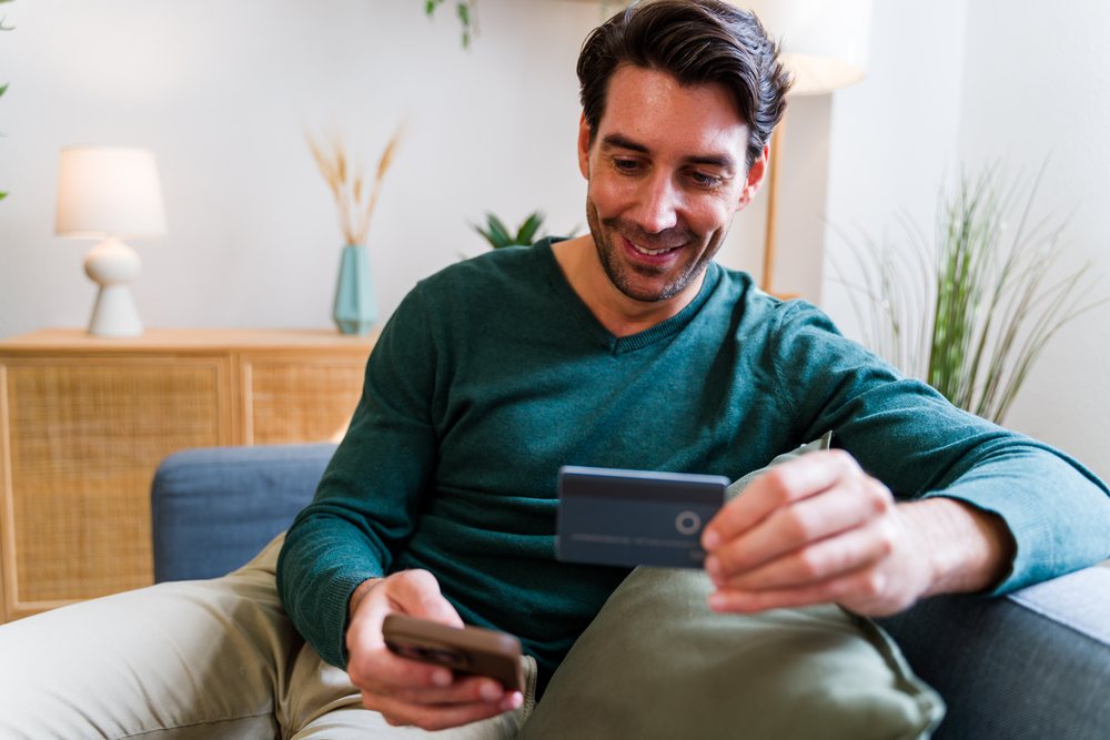 White man credit card and smartphone on sofa indoors