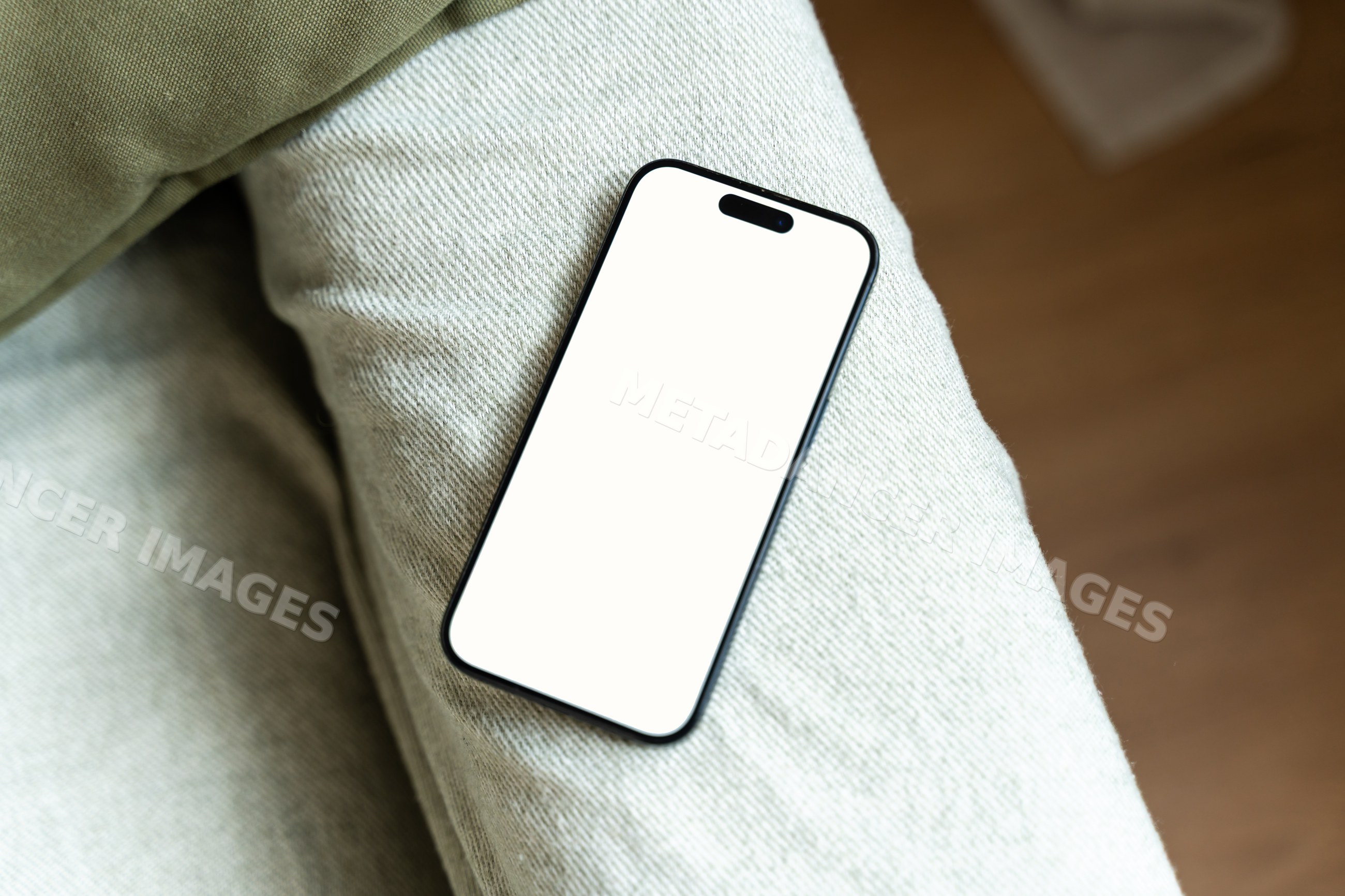 Smartphone with white screen lying on pants indoors