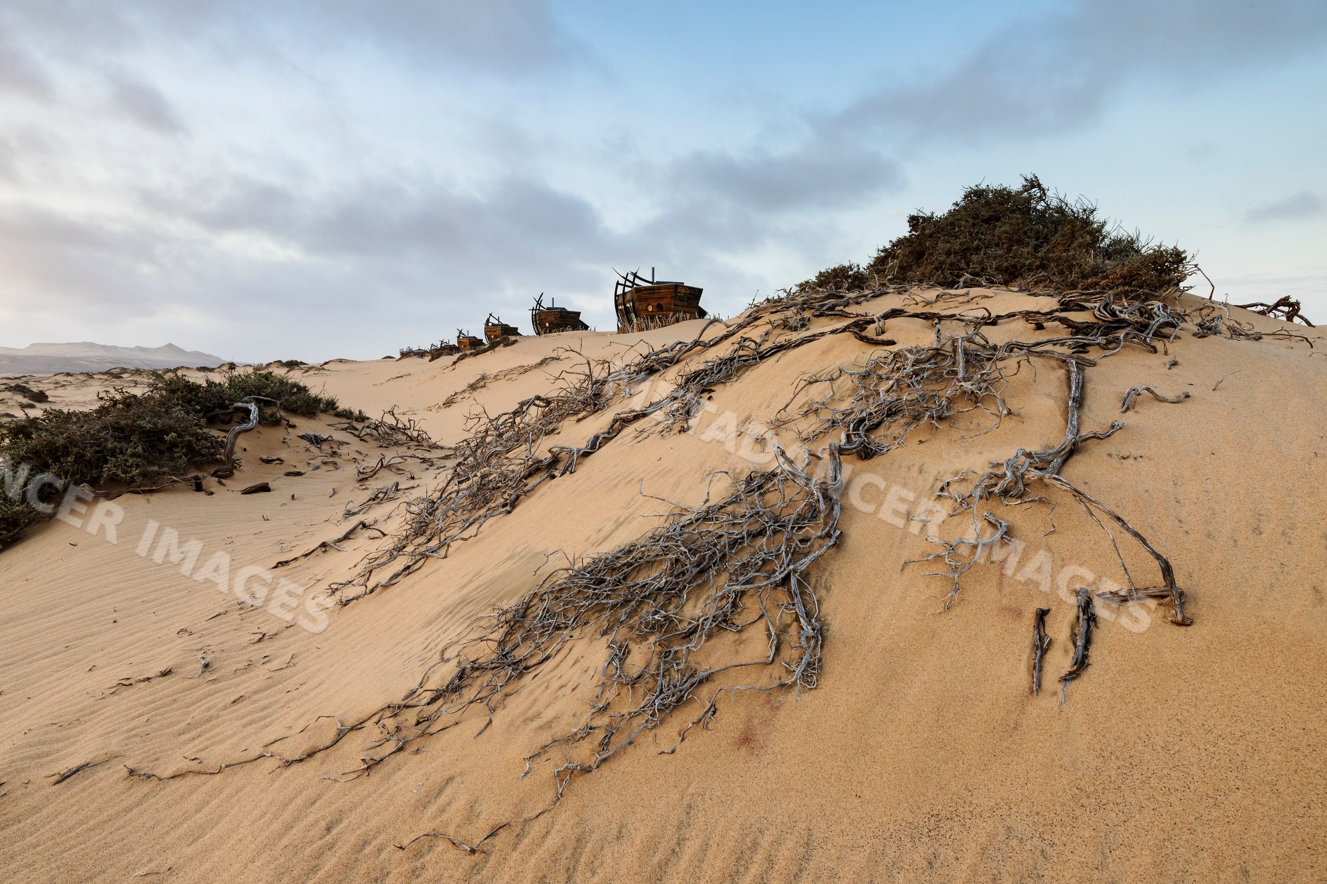 Shipwreck lodge ruins on sand dunes at Sunset in Namibia