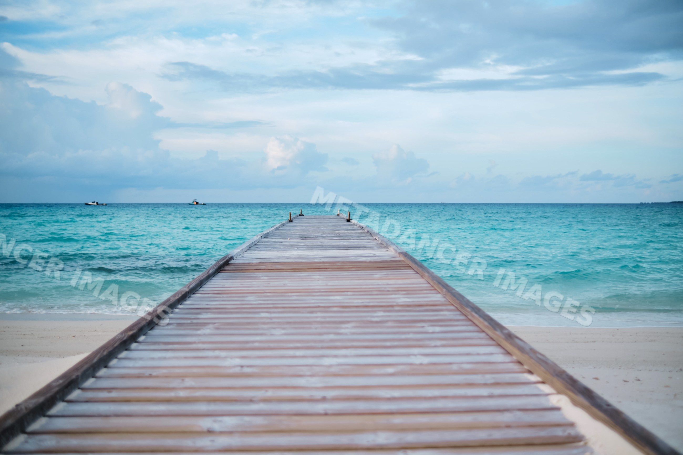 A wooden pier leading into the turquoise ocean