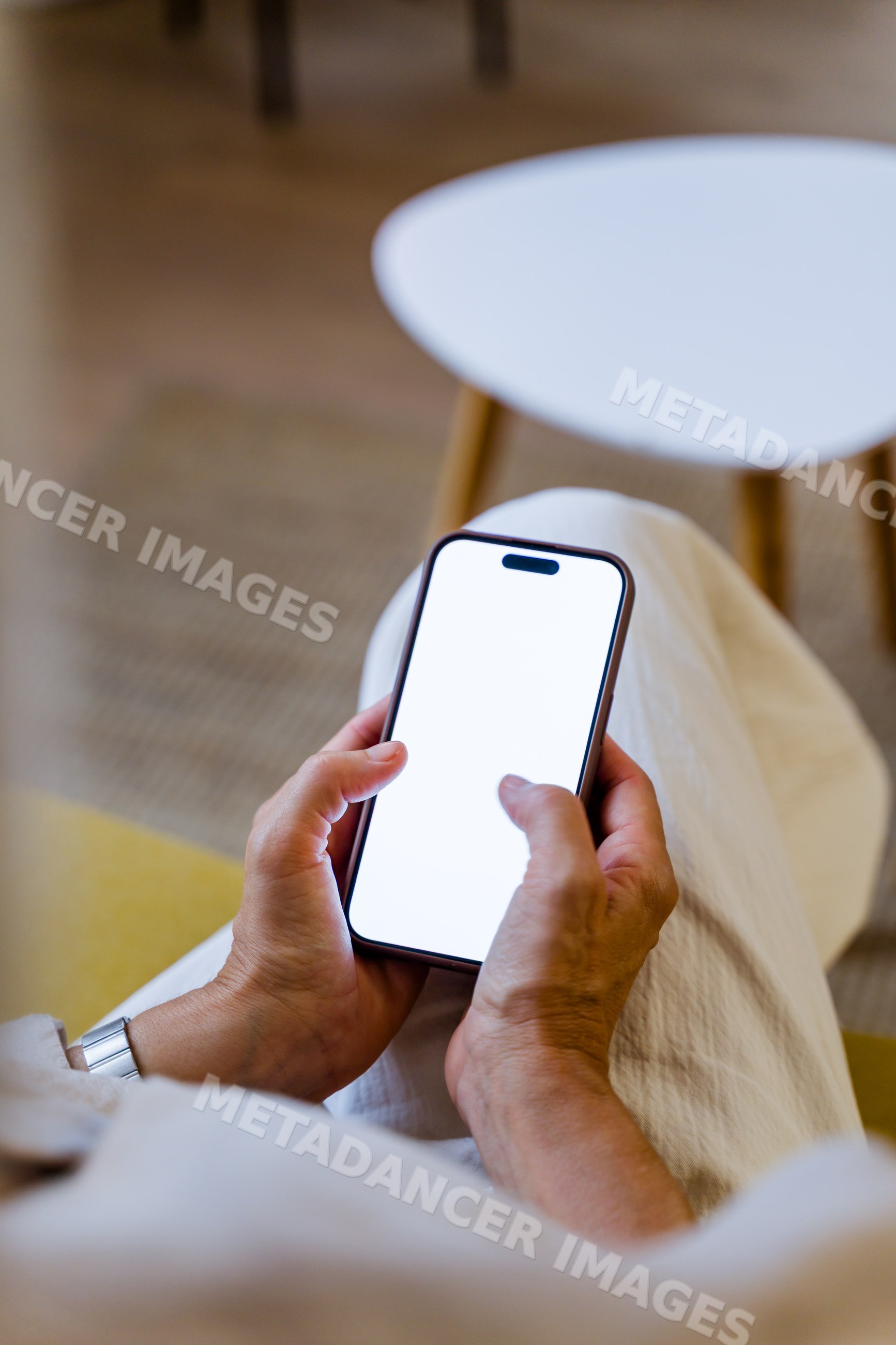 White person a smartphone indoors near a table