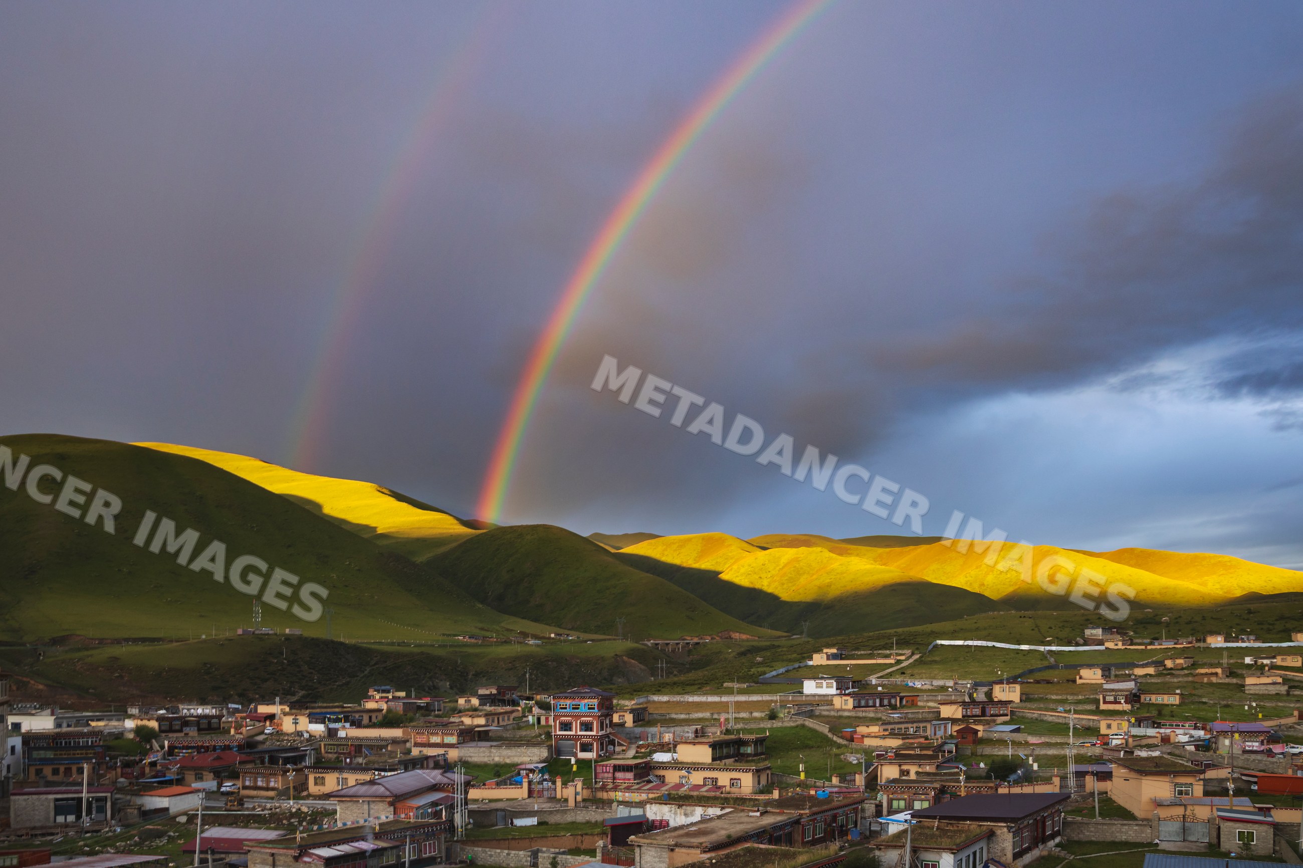 Double rainbow over hills and village at Sunset in Zhuqing