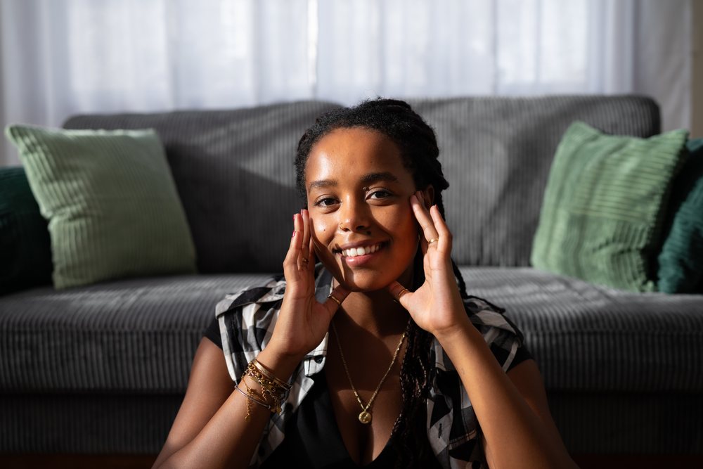 A smiling African American woman sitting comfortably in a living room