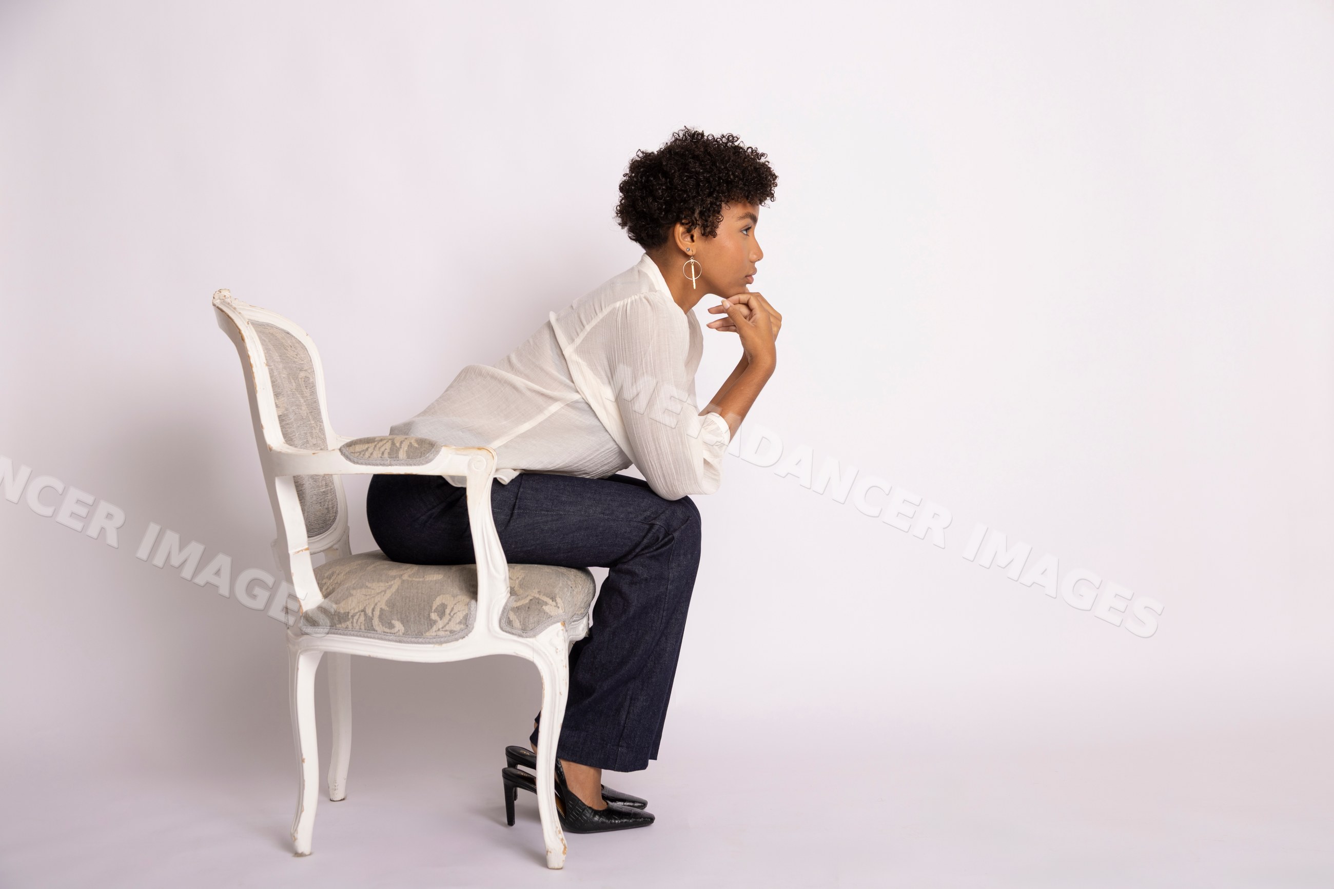Hispanic woman sitting thoughtfully on an elegant chair