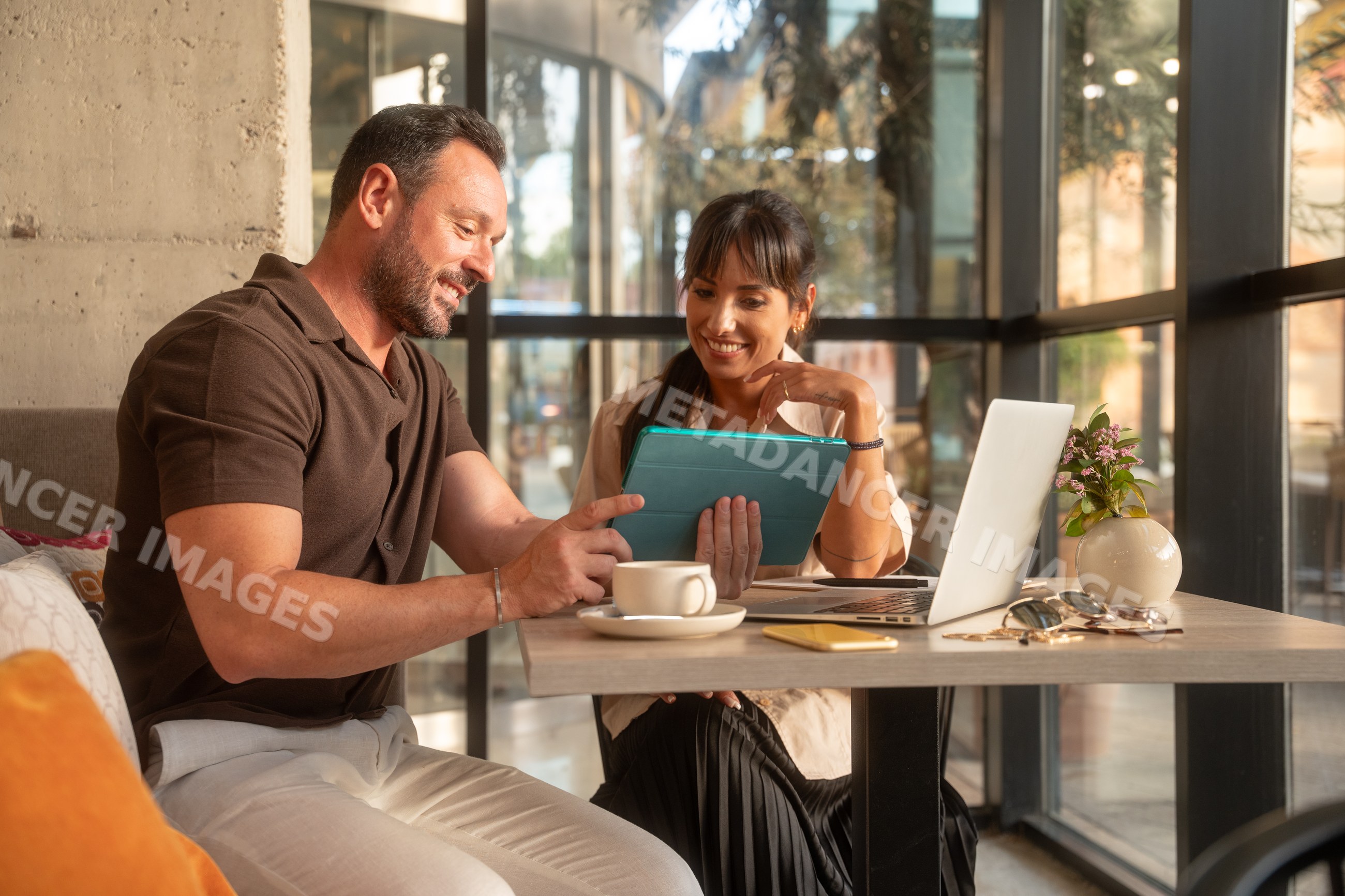Coworkers collaborating with technology in an office in Seville