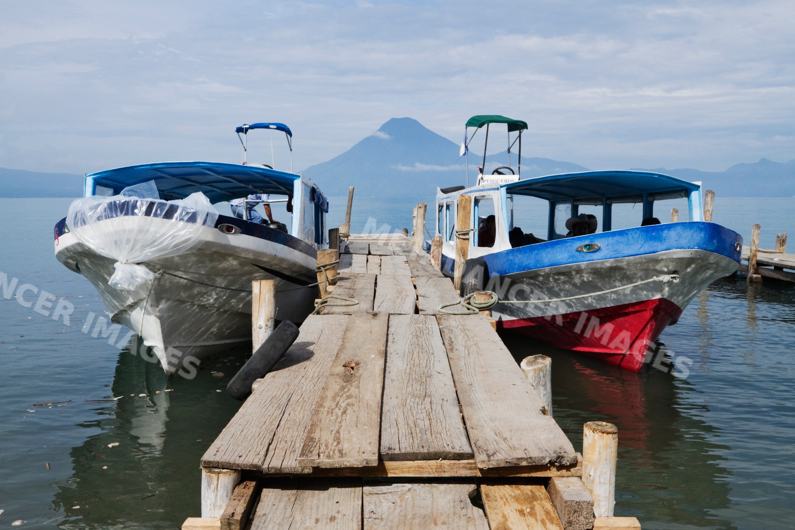 Water taxis docked on lake atitlan with volcano