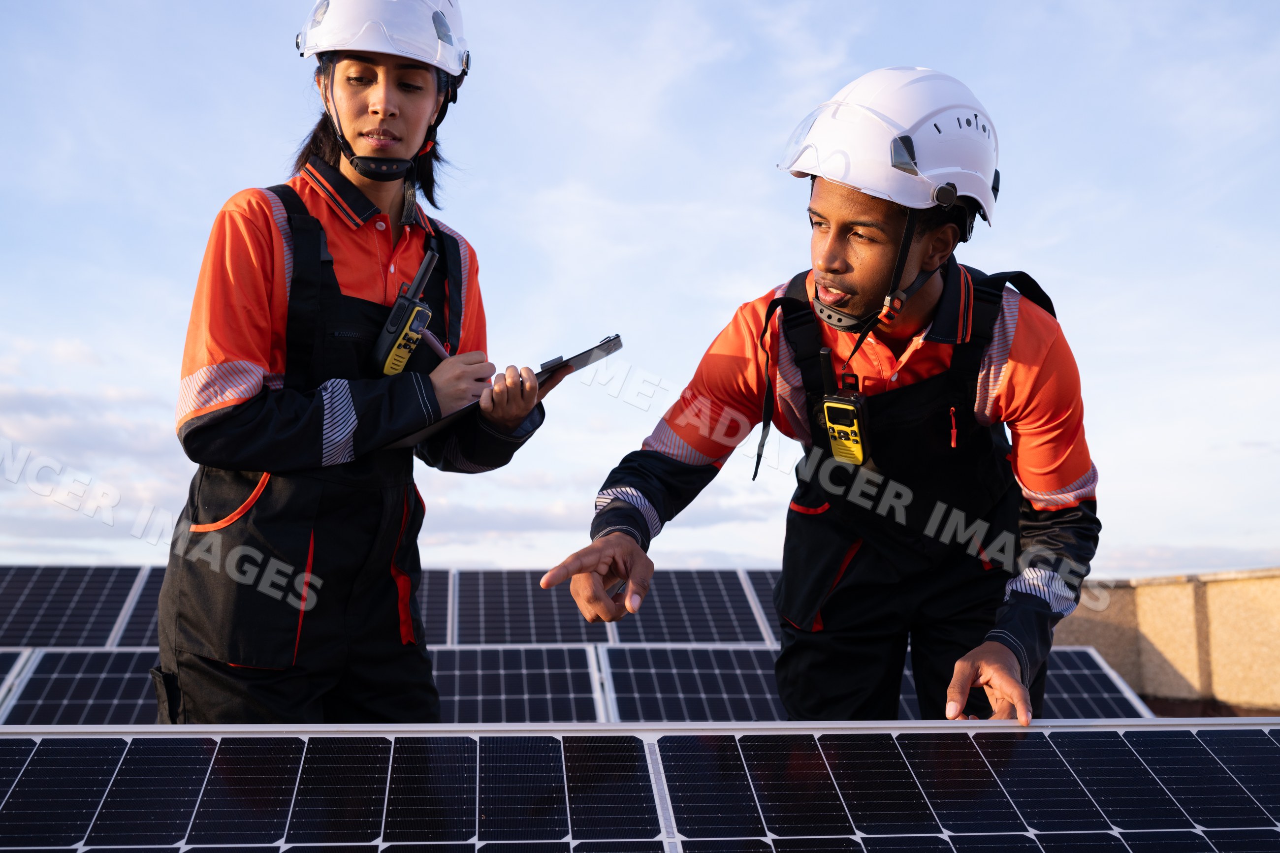 Solar energy technicians inspect panels outdoors