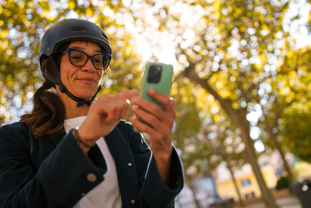 Hispanic woman using smartphone outdoors