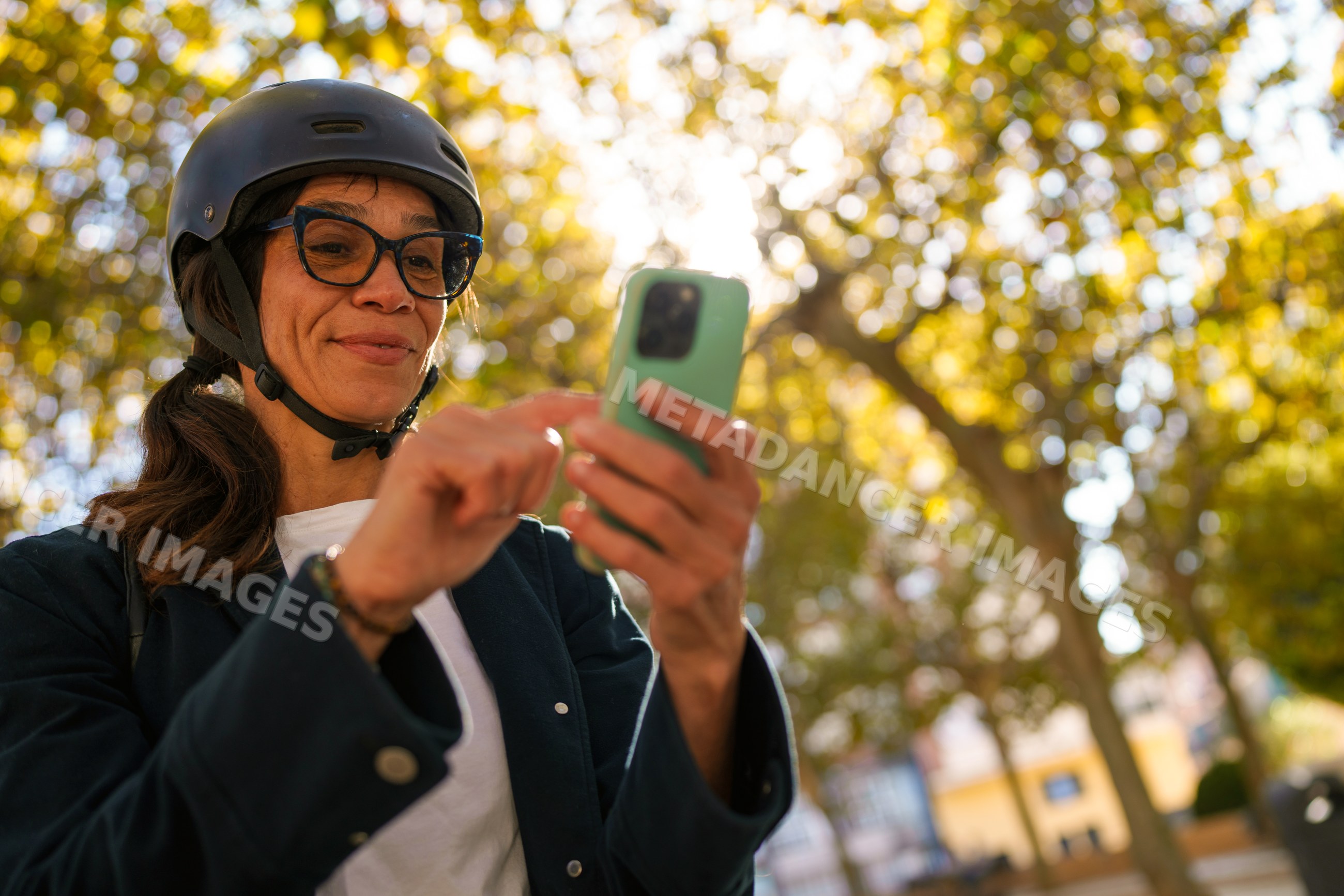 Hispanic woman using smartphone outdoors