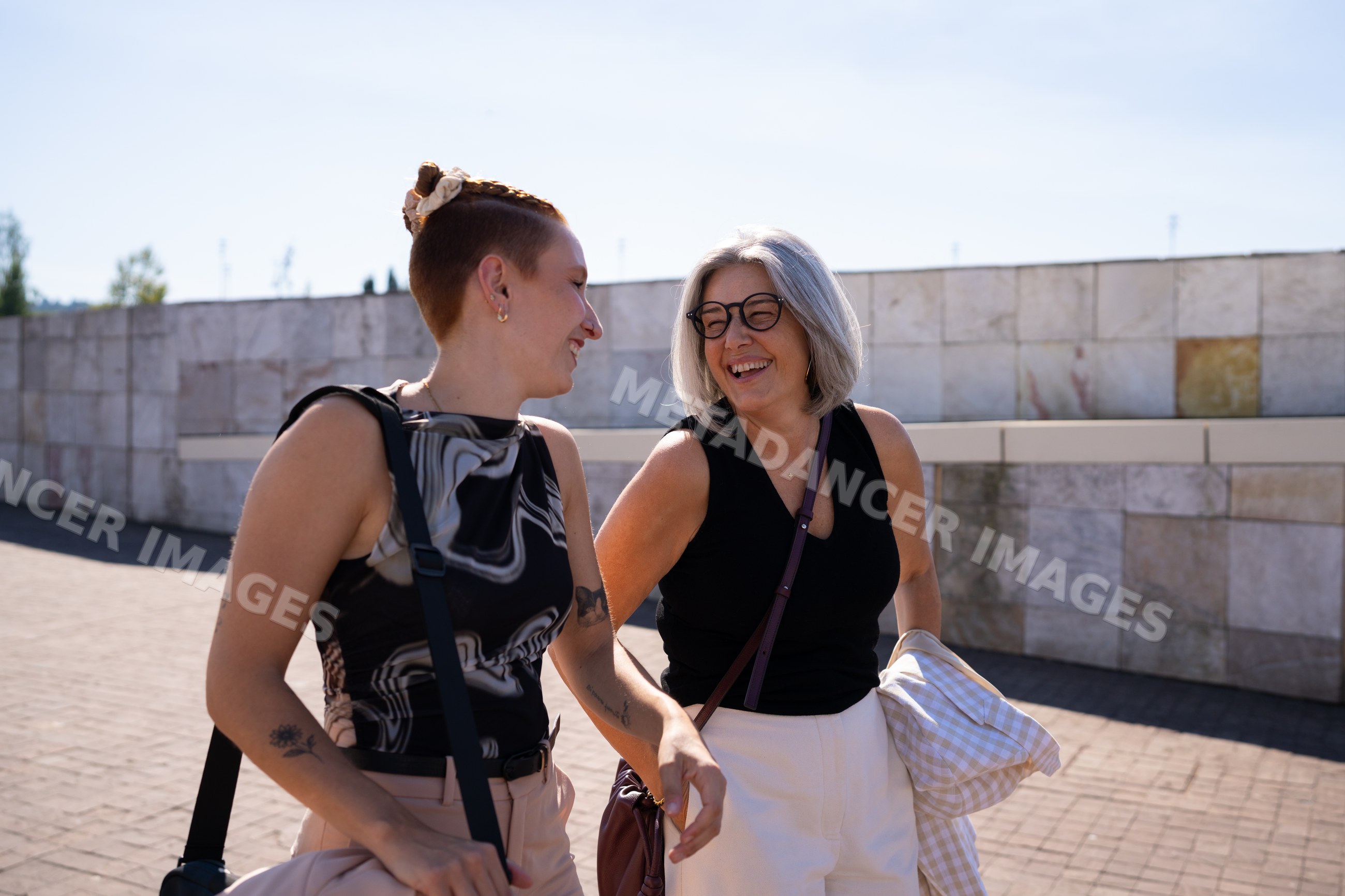 Two white women walking and laughing outdoors