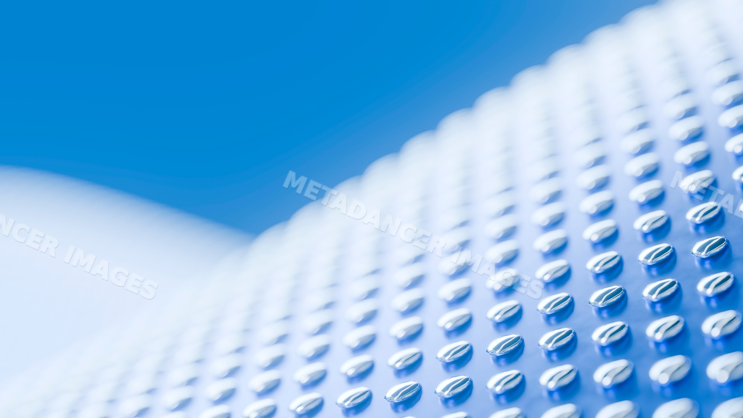 Metal surface with rows of raised ovals creating abstract pattern