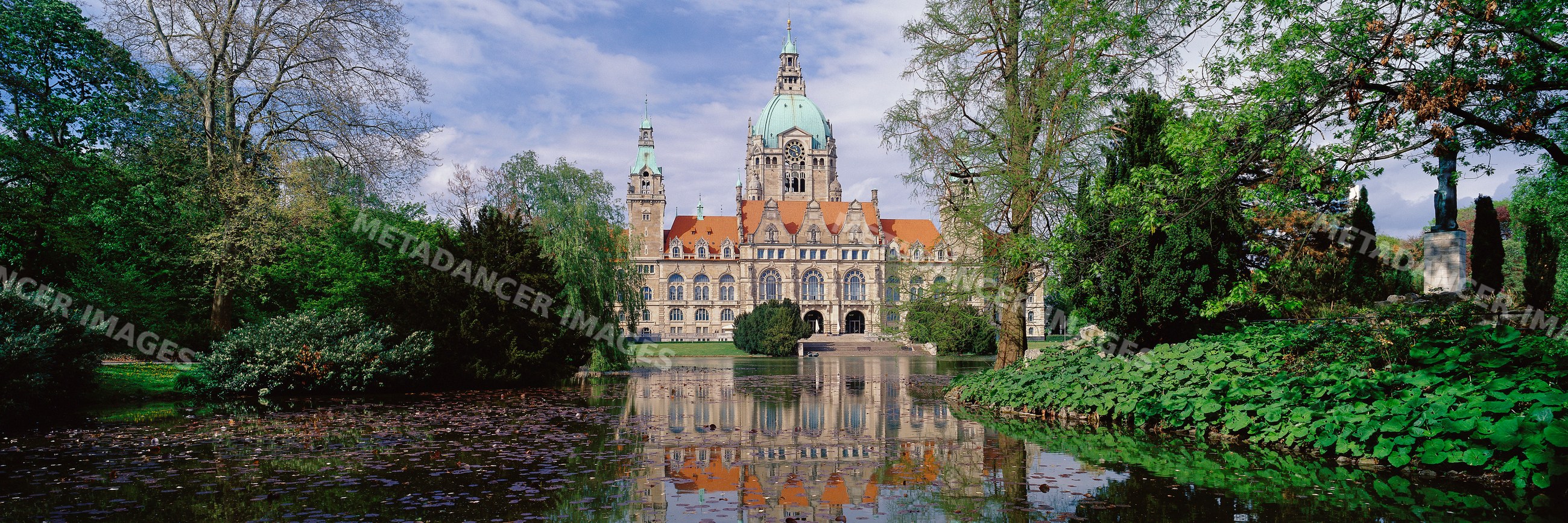 New city hall hannover reflected in pond with lush park greenery