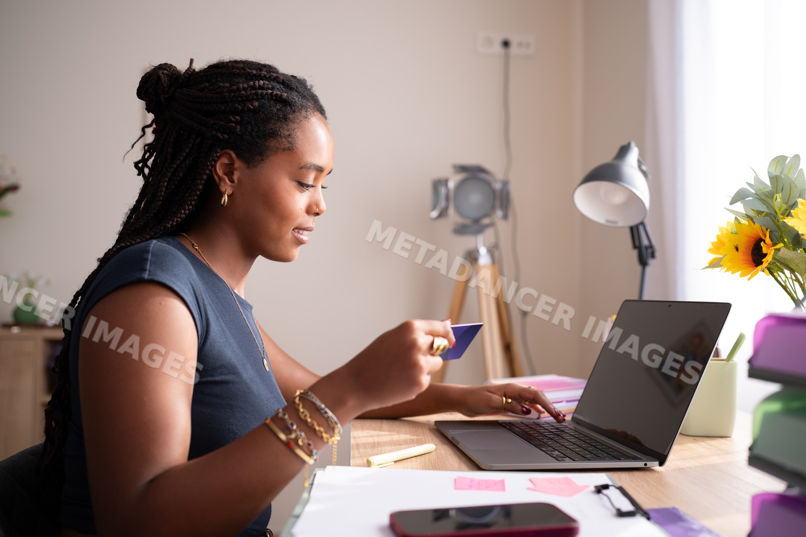 A black African American woman shops online from her laptop