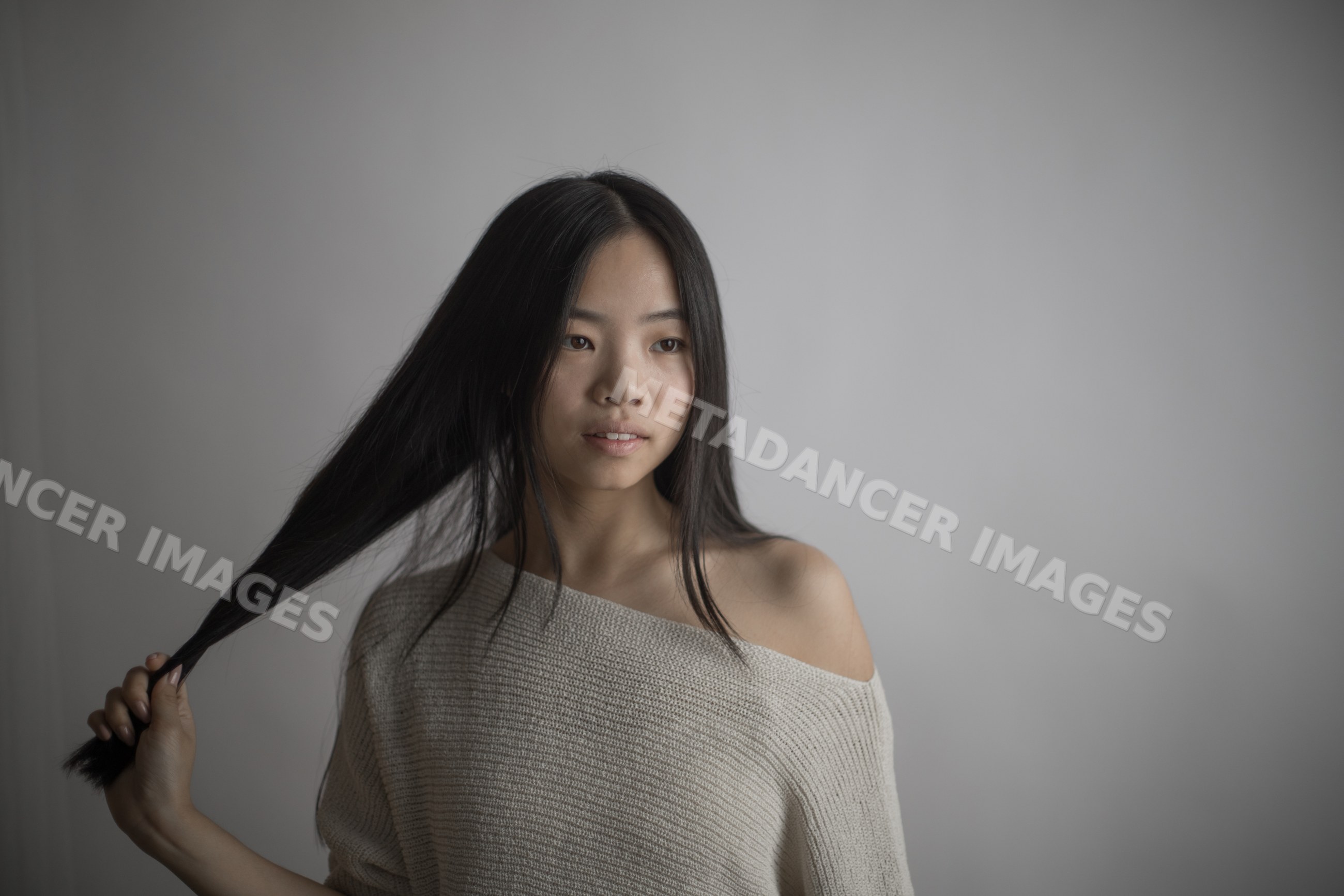 Young Southeast Asian woman holding long hair