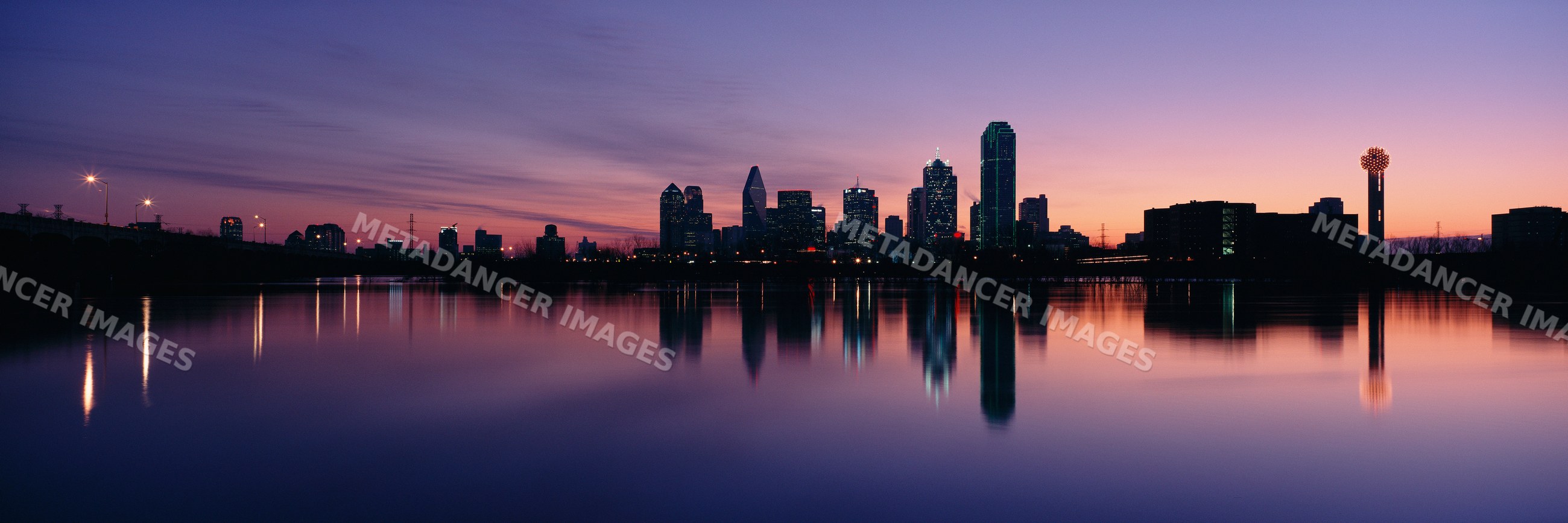 City skyline of dallas, texas at sunset with water reflections