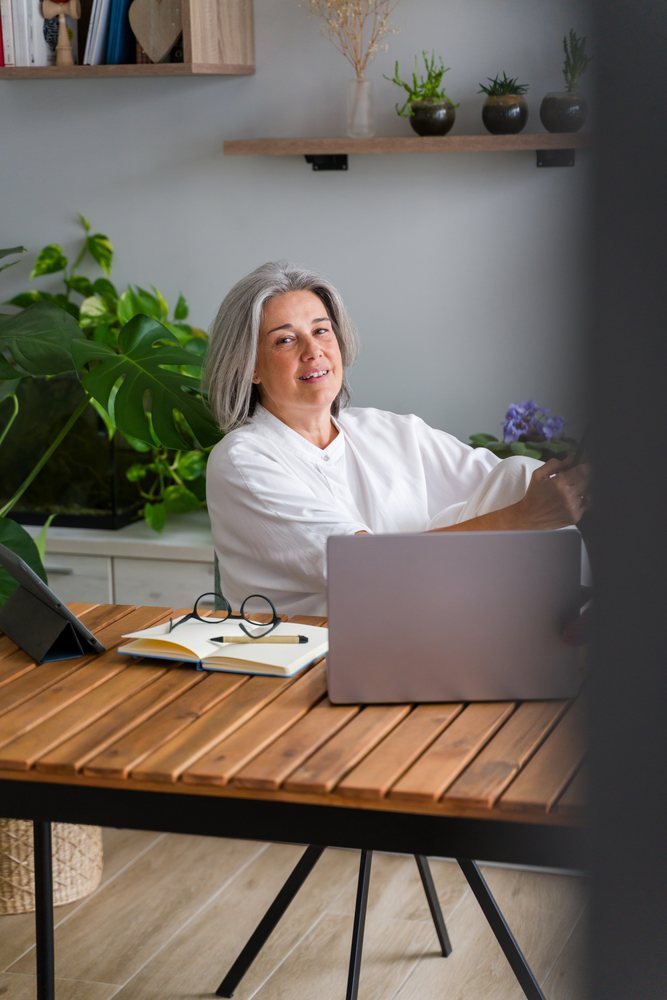 Mature white woman working on laptop in modern home office in a office