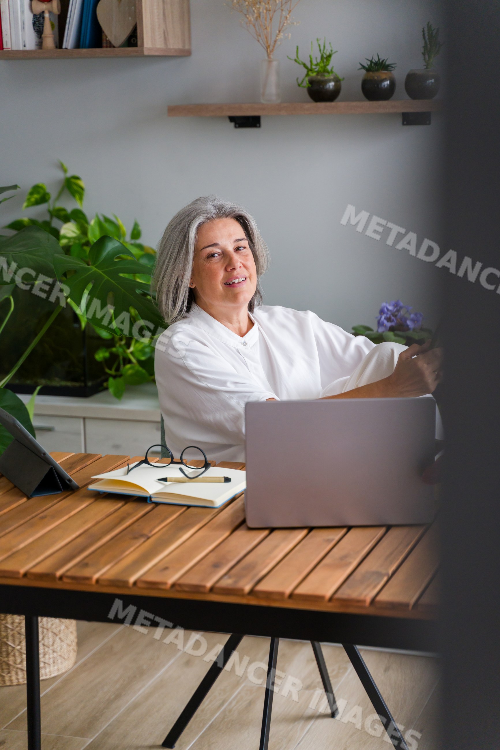Mature white woman working on laptop in modern home office in a office