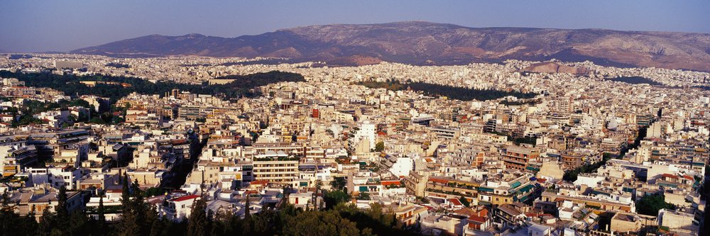Cityscape of athens, greece with urban buildings and mountains