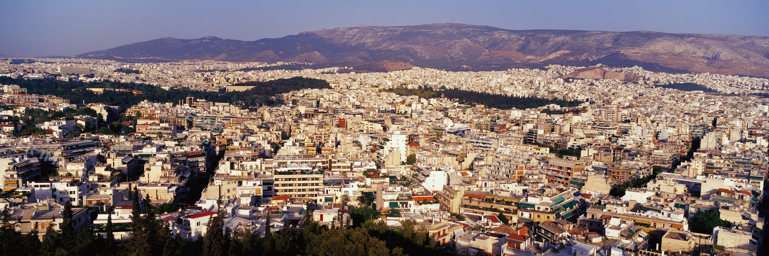 Cityscape of athens, greece with urban buildings and mountains